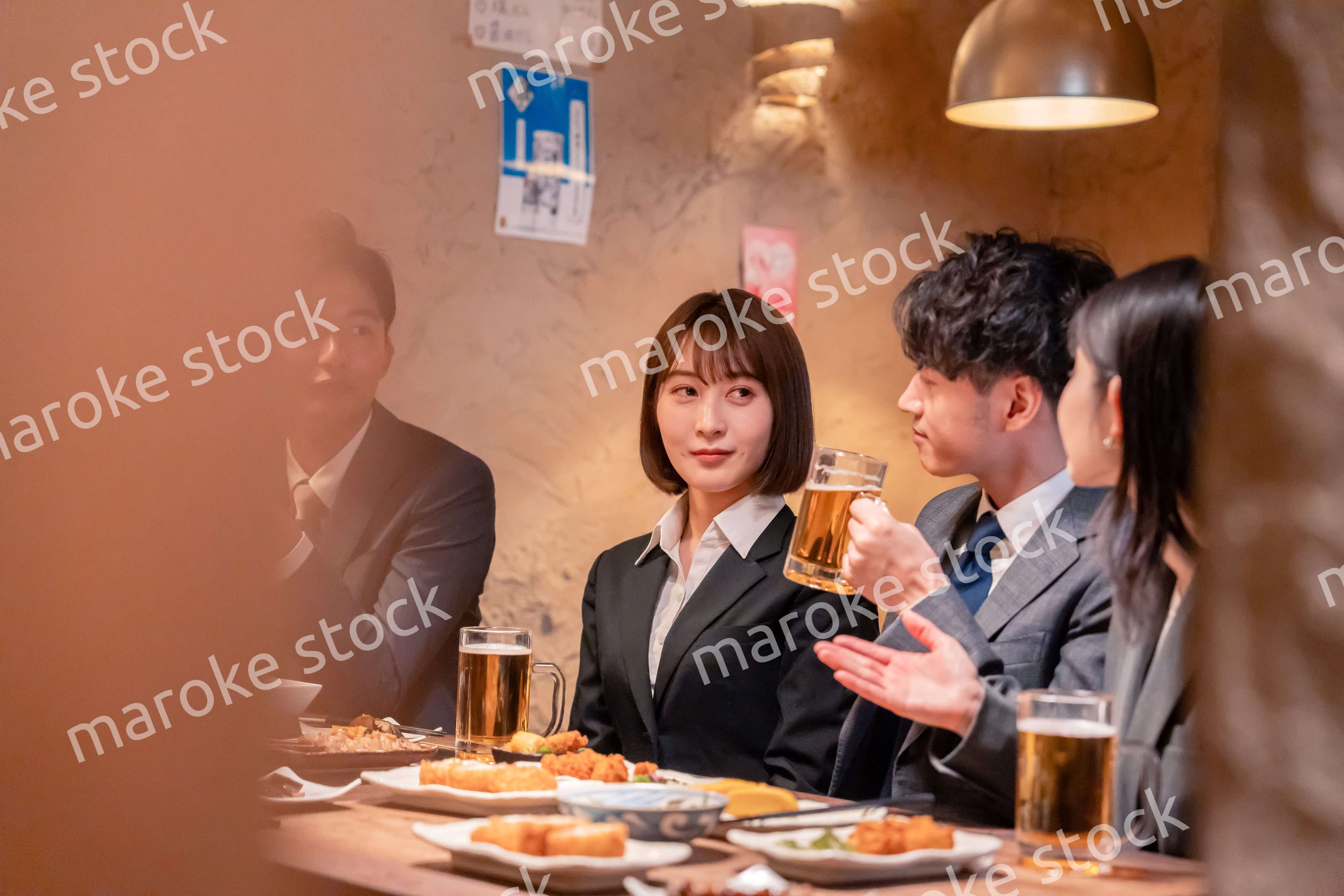 居酒屋で新入社員の歓迎会をするビジネスパーソン