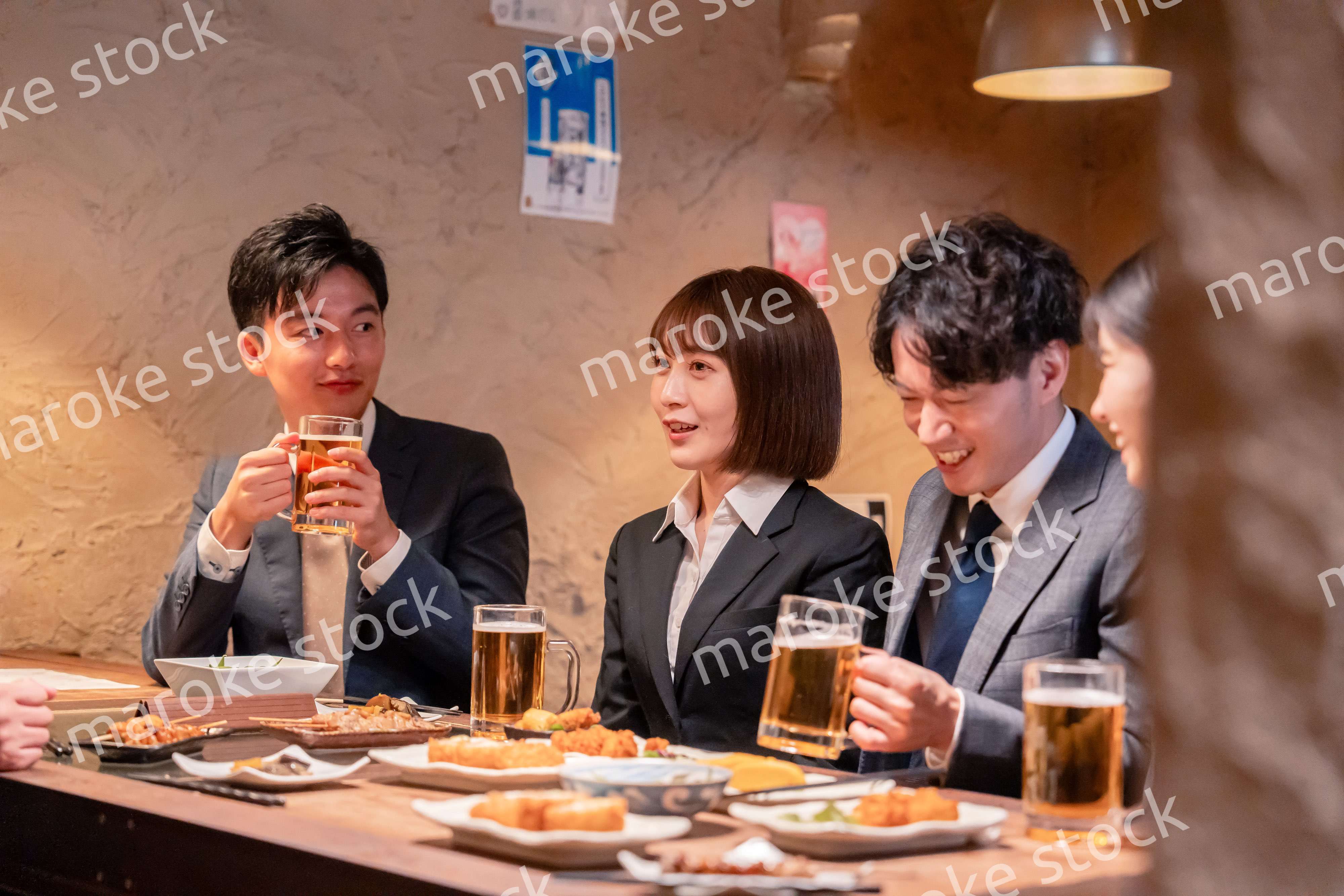 居酒屋で新入社員の歓迎会をするビジネスパーソン