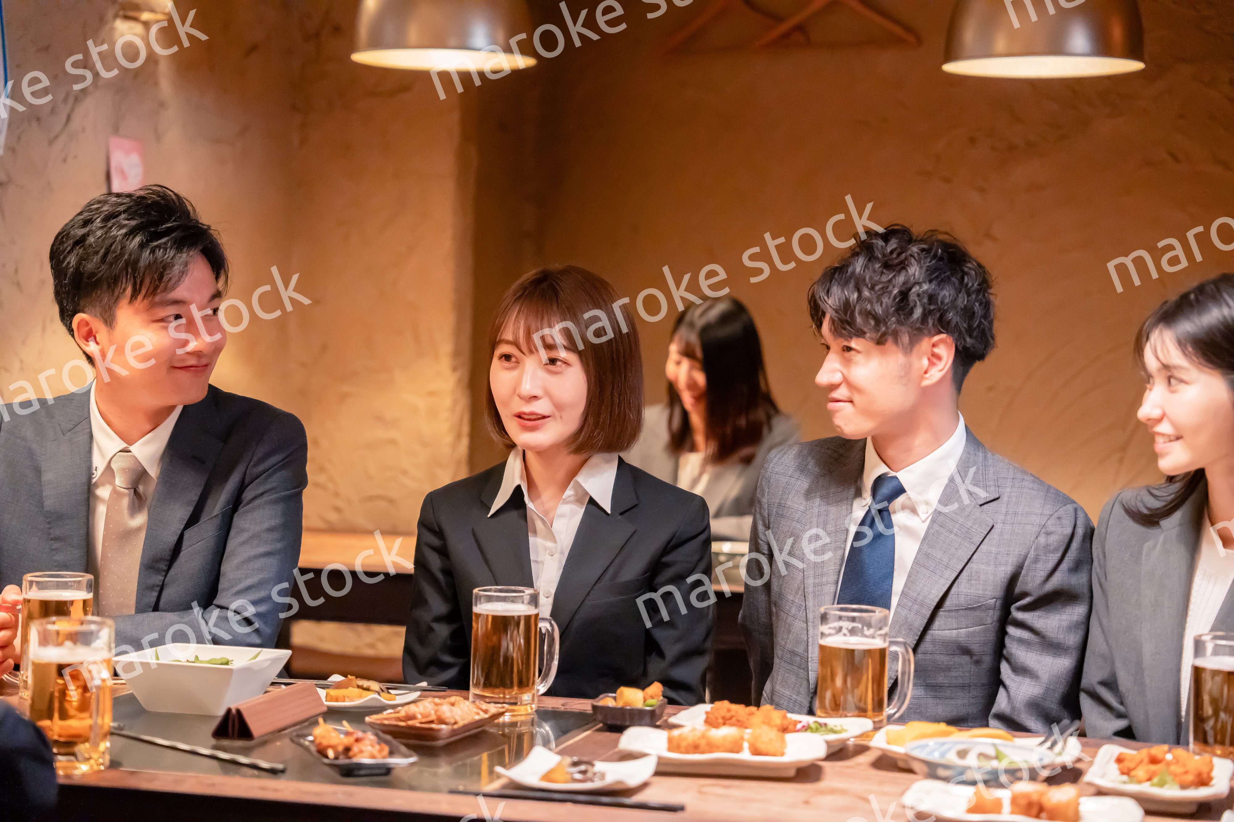 居酒屋で新入社員の歓迎会をするビジネスパーソン