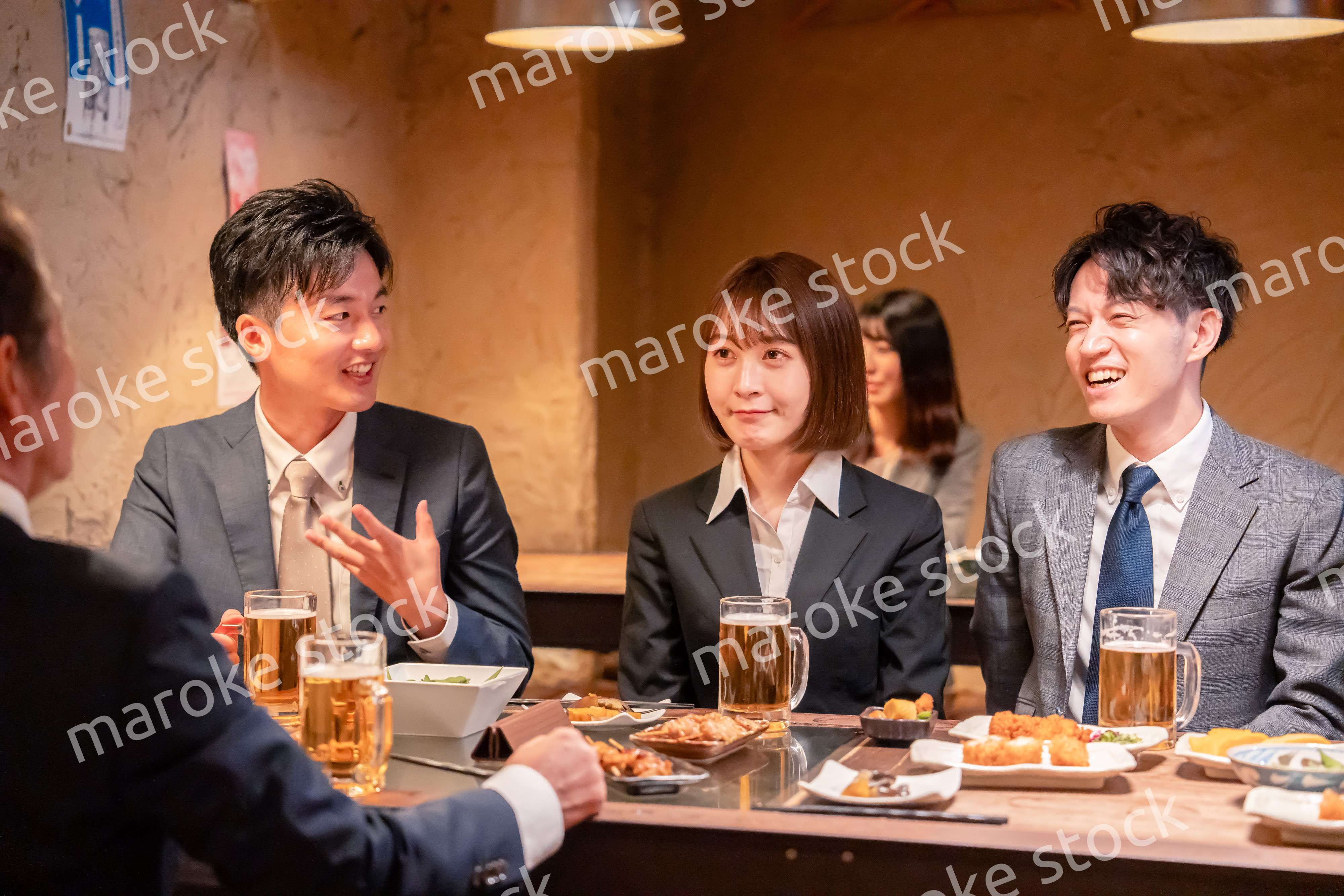 居酒屋で新入社員の歓迎会をするビジネスパーソン