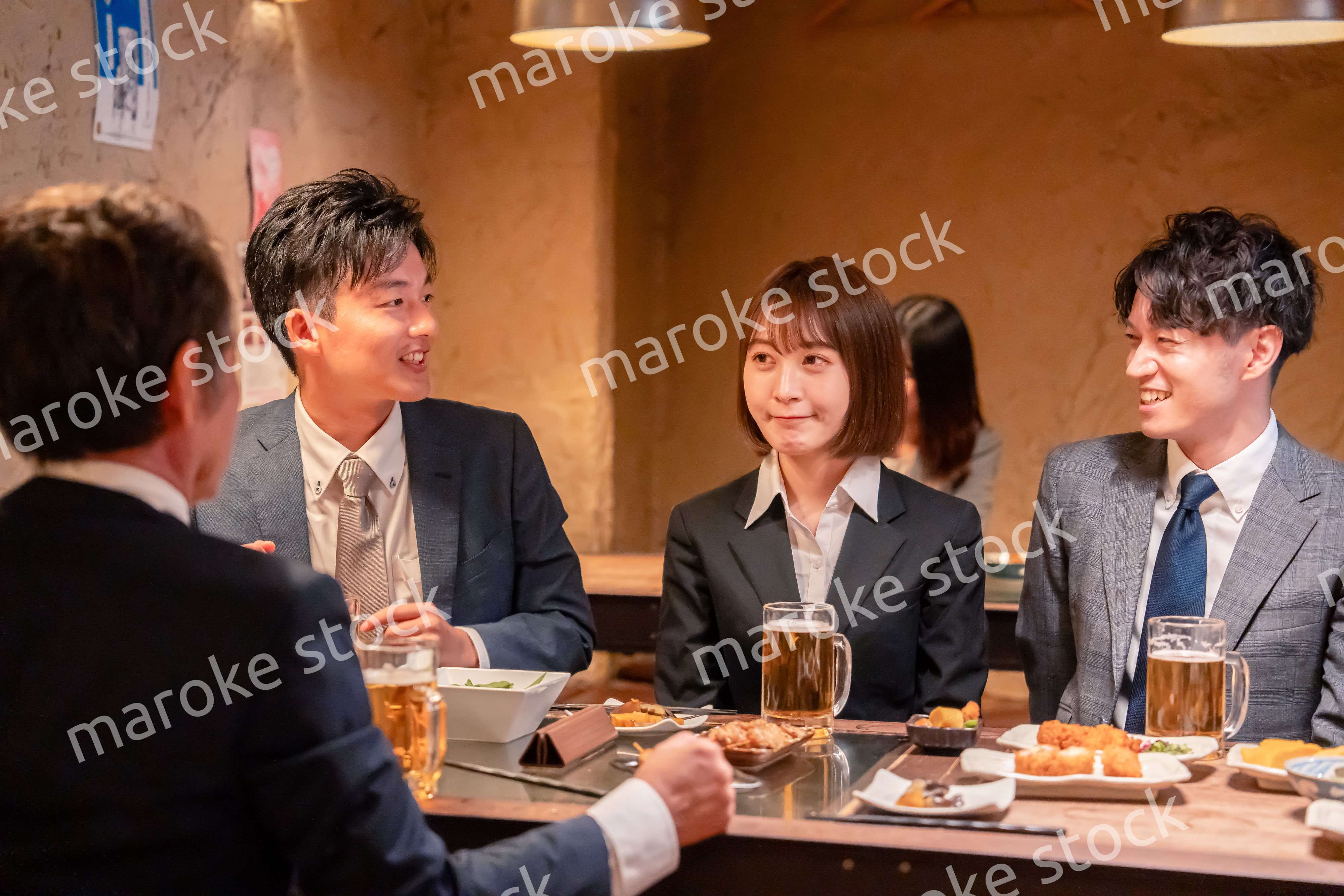 居酒屋で新入社員の歓迎会をするビジネスパーソン