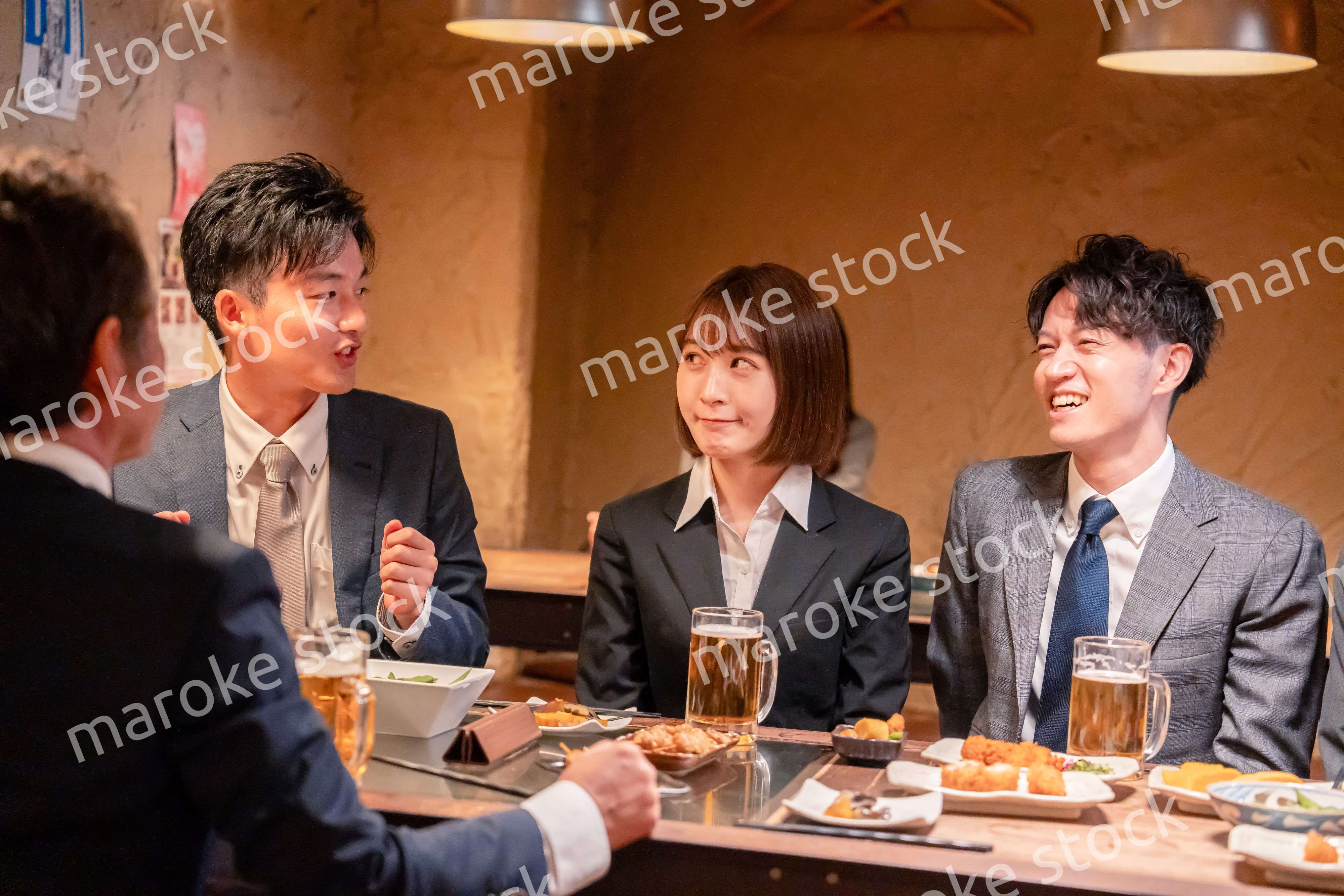 居酒屋で新入社員の歓迎会をするビジネスパーソン