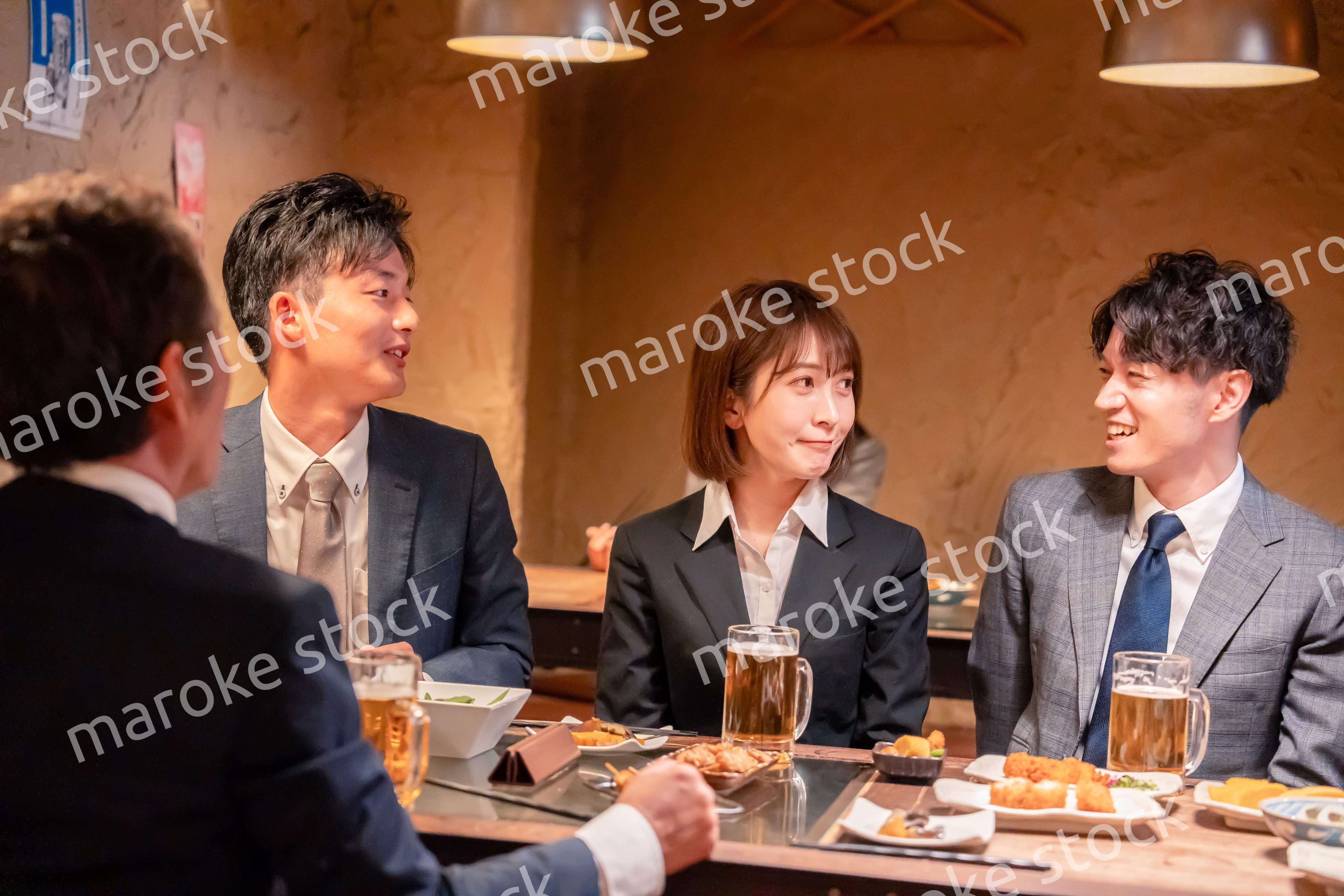 居酒屋で新入社員の歓迎会をするビジネスパーソン