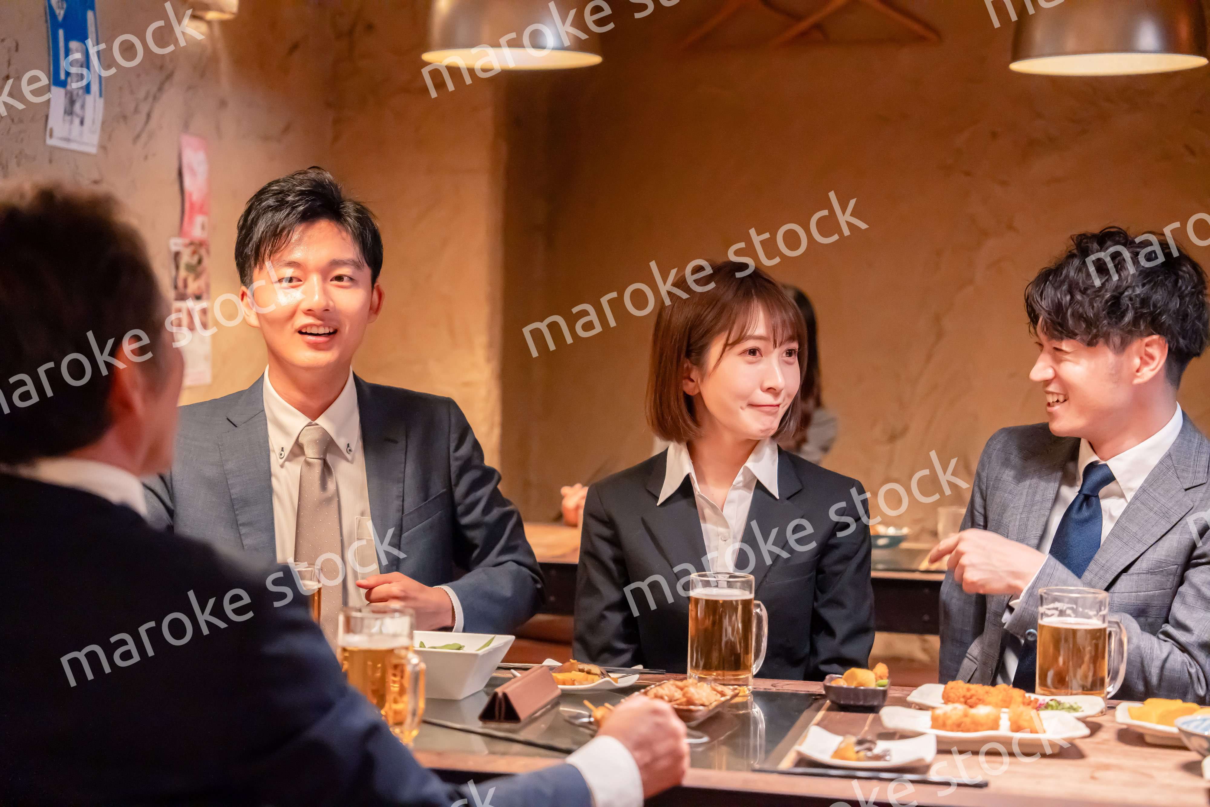 居酒屋で新入社員の歓迎会をするビジネスパーソン