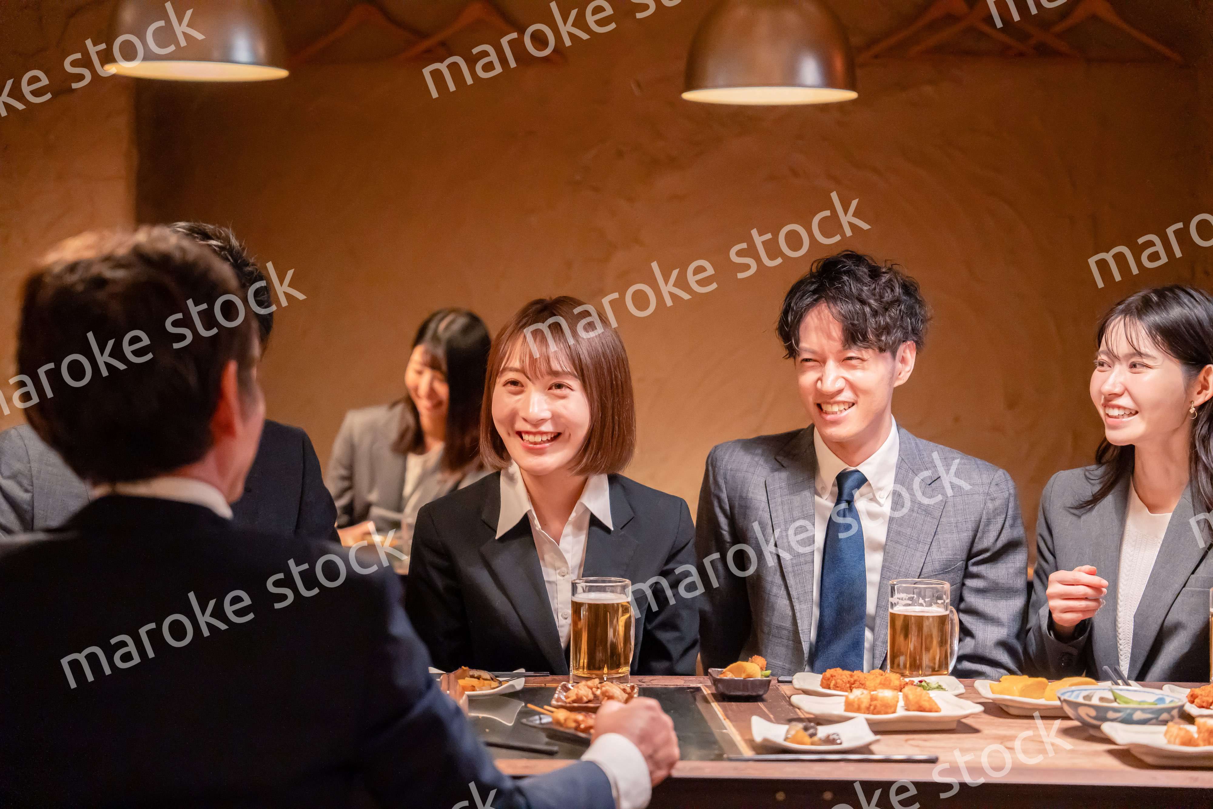 居酒屋で新入社員の歓迎会をするビジネスパーソン