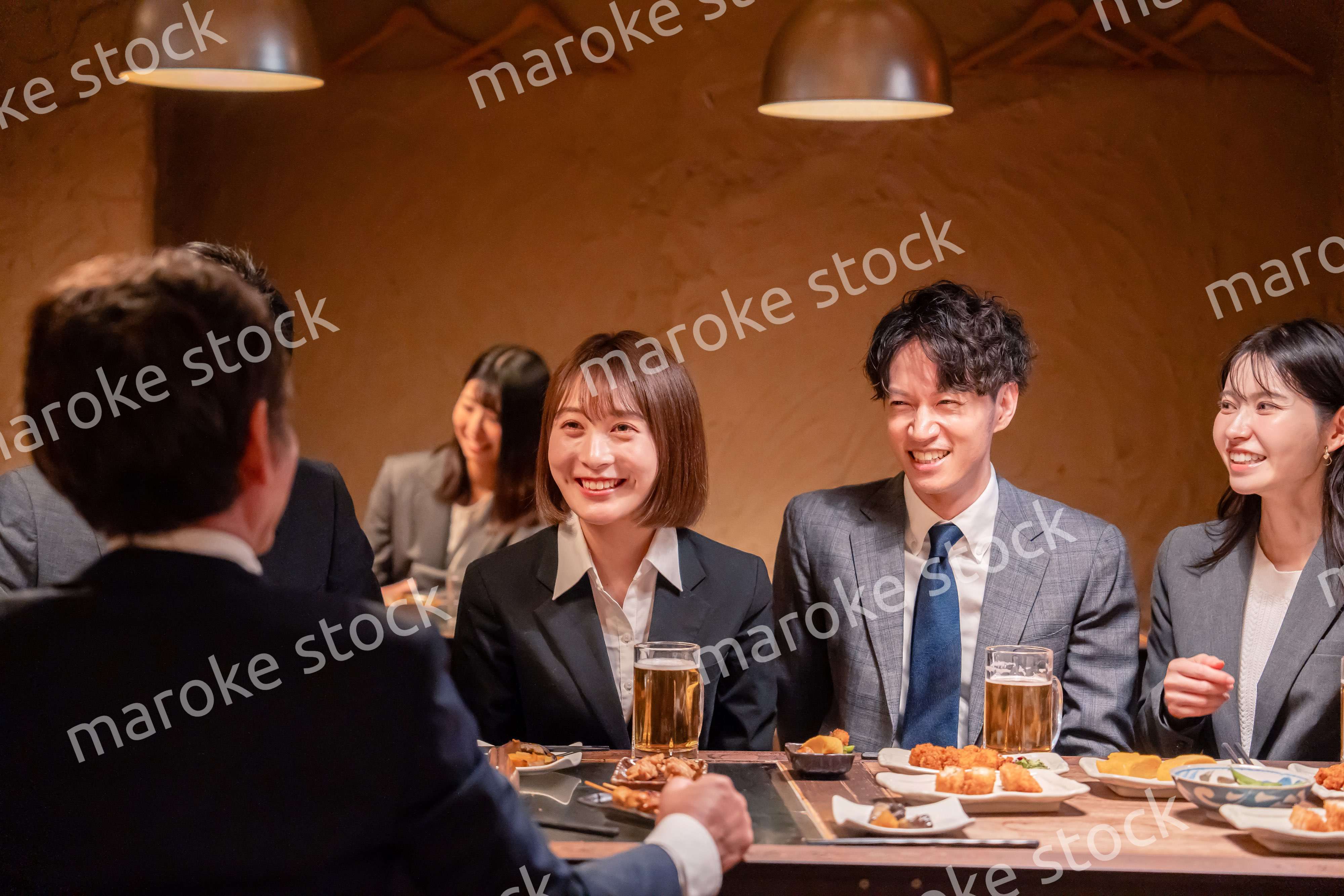 居酒屋で新入社員の歓迎会をするビジネスパーソン