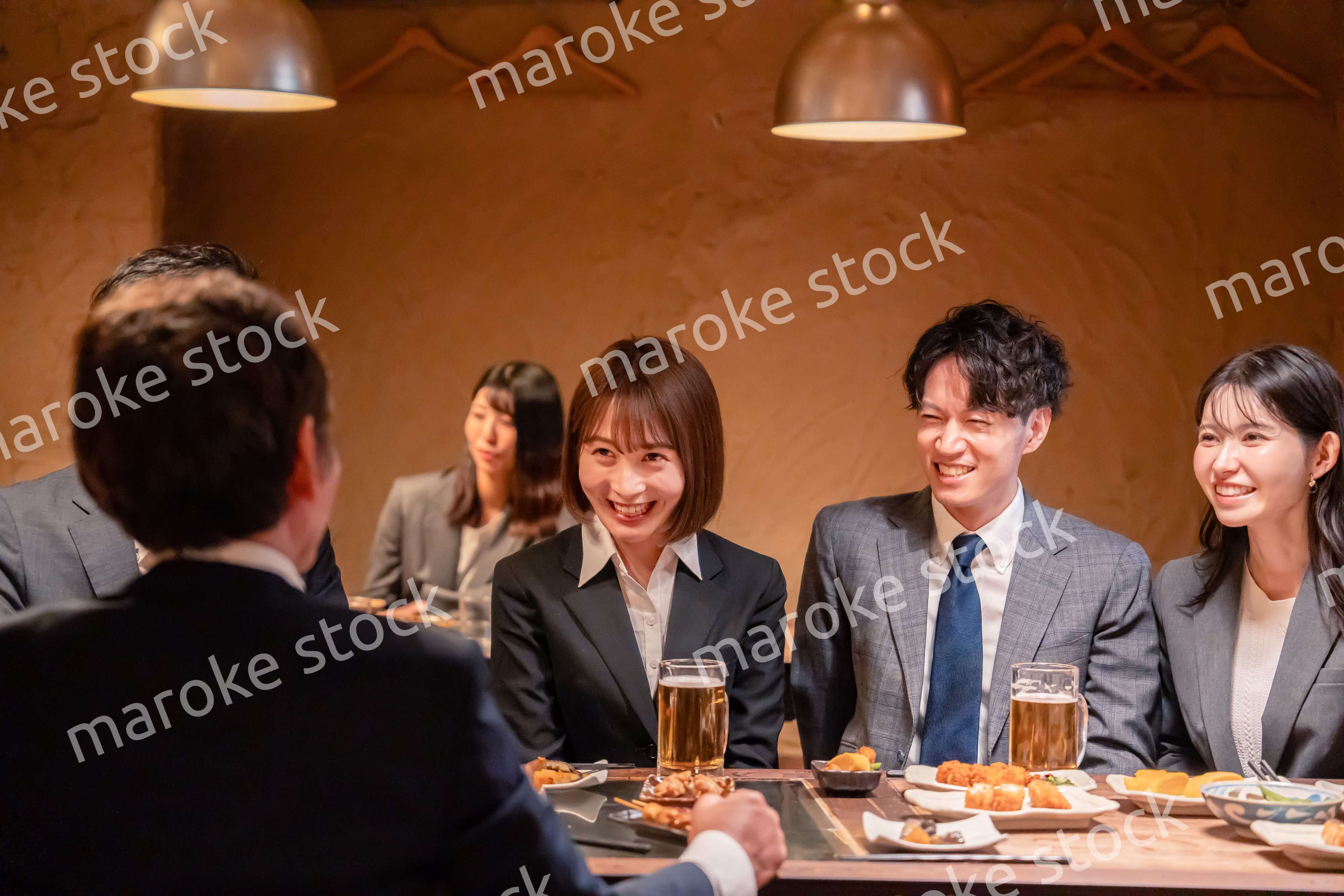 居酒屋で新入社員の歓迎会をするビジネスパーソン