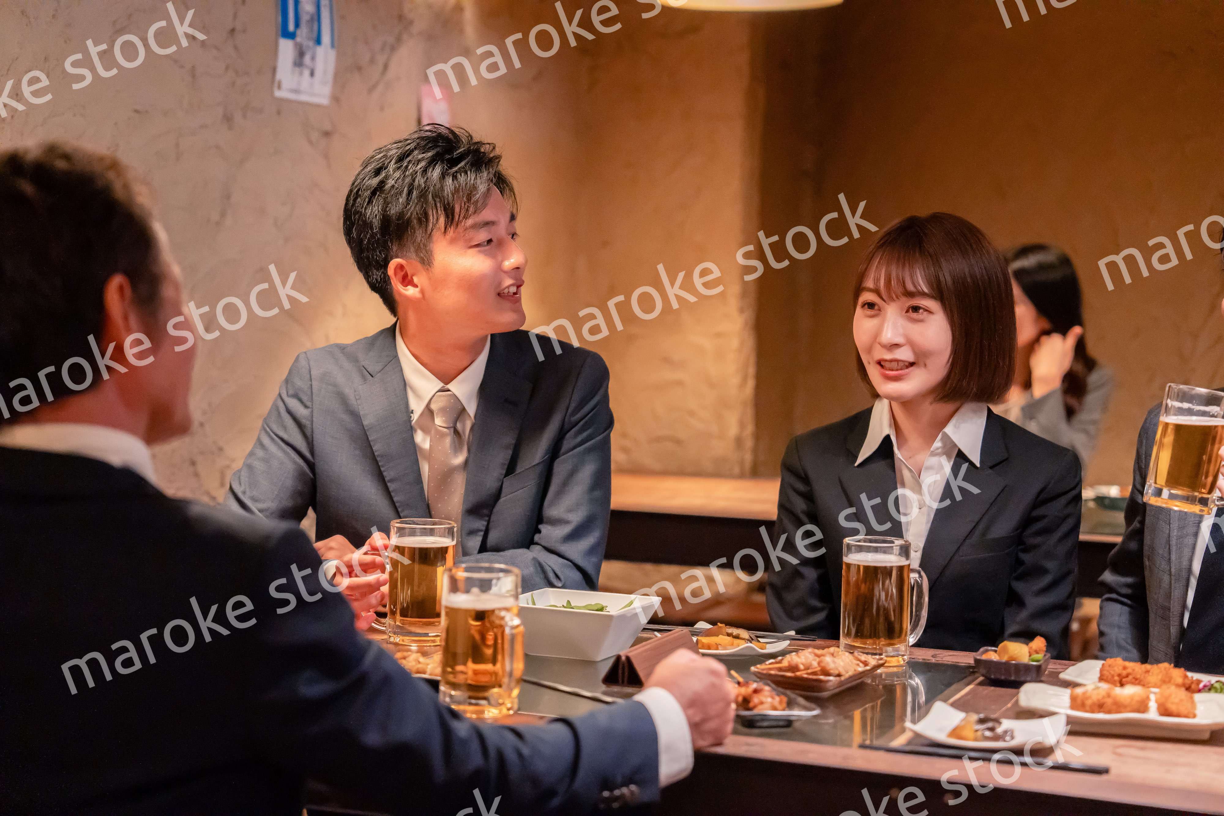 居酒屋で新入社員の歓迎会をするビジネスパーソン