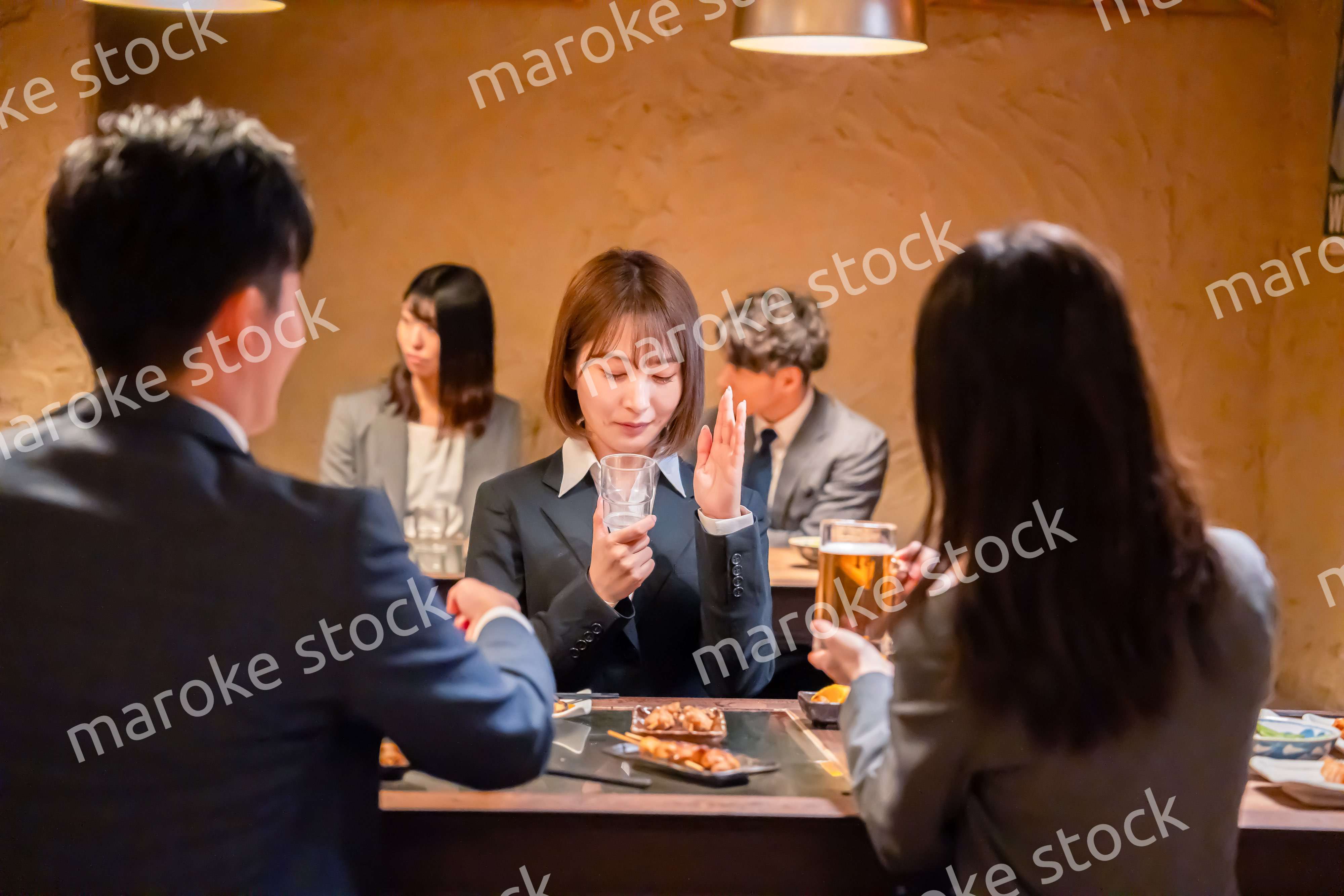 居酒屋で先輩社員にアルコールを勧められて断る女性社員