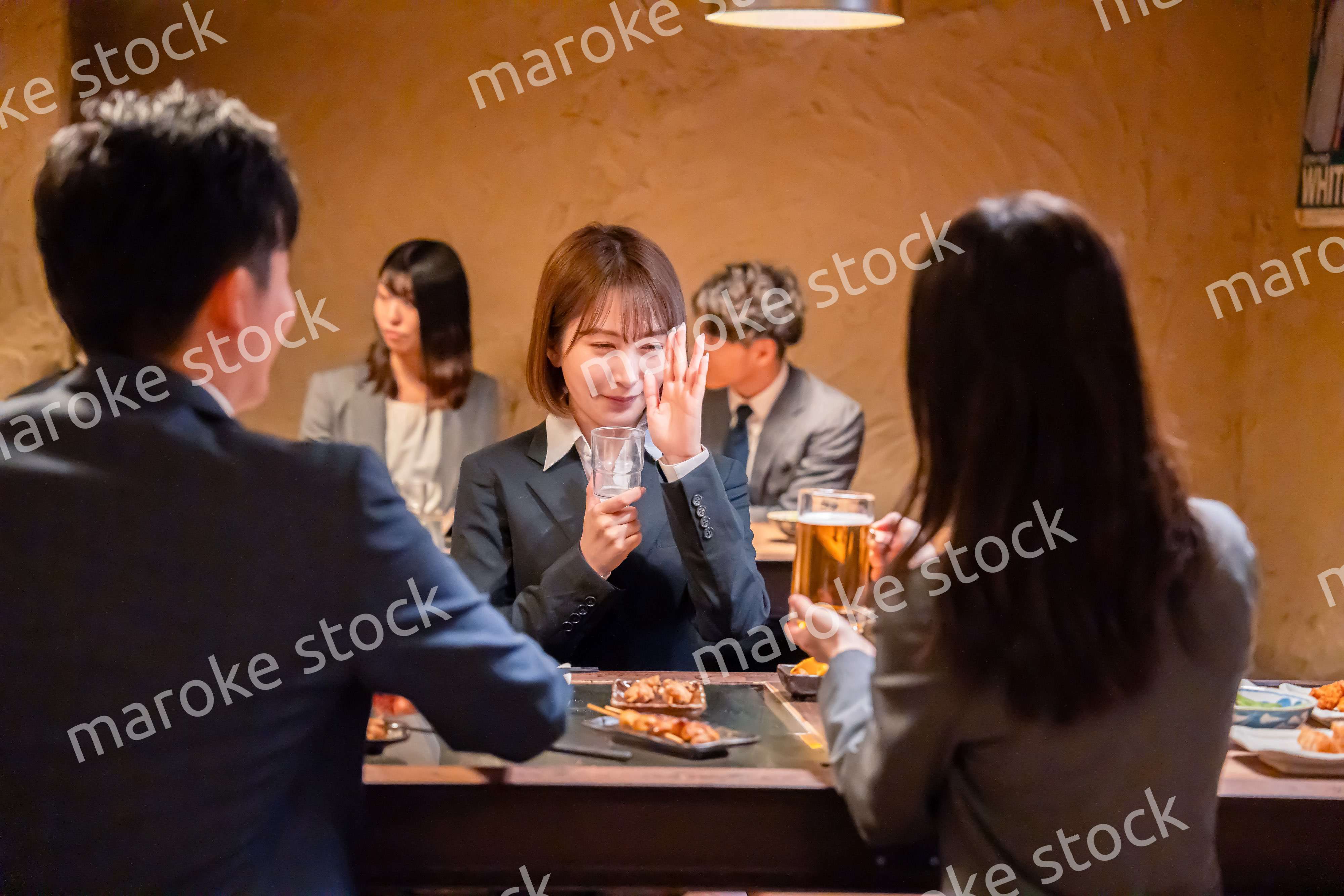 居酒屋で先輩社員にアルコールを勧められて断る女性社員