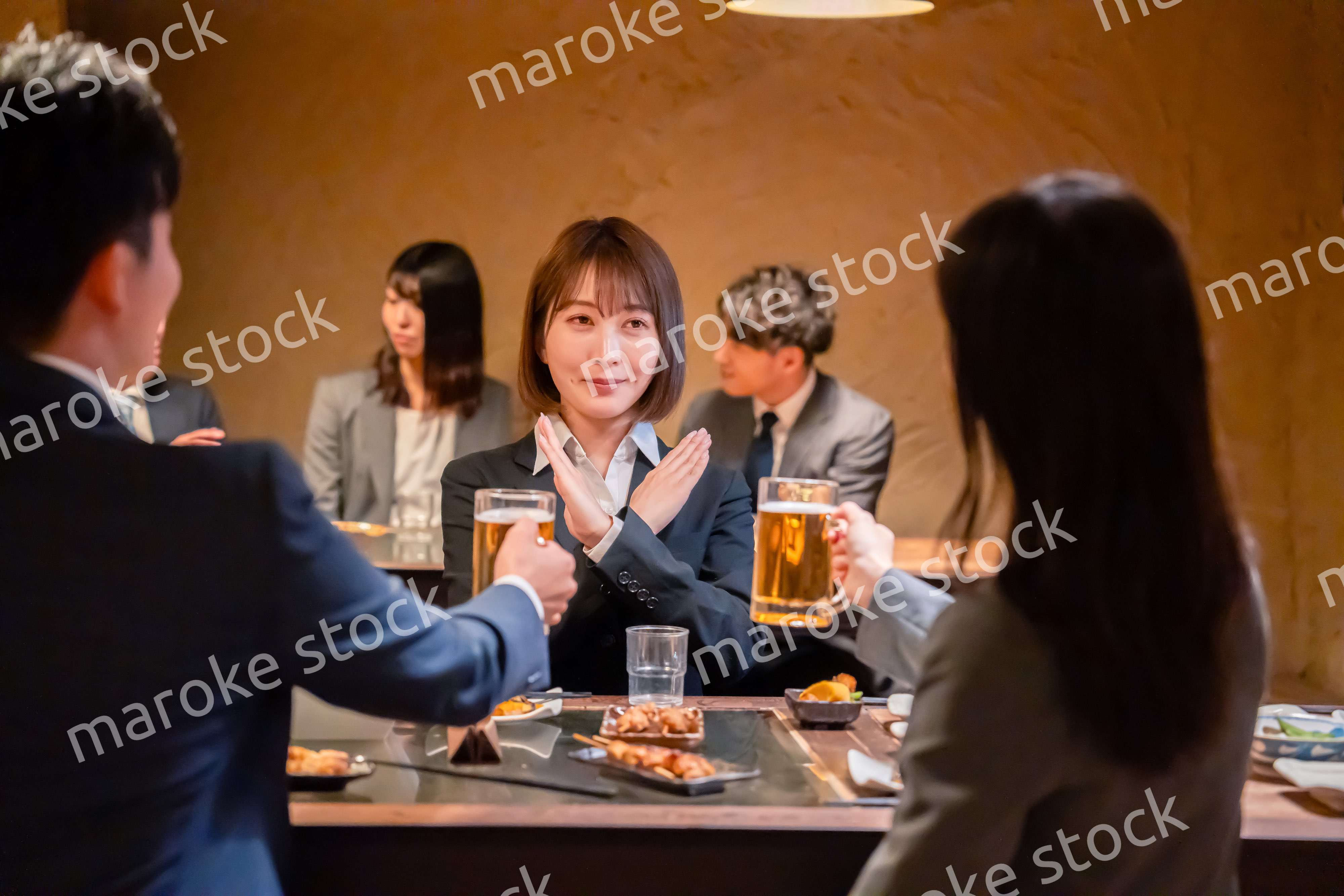 居酒屋で先輩社員にアルコールを勧められて断る女性社員