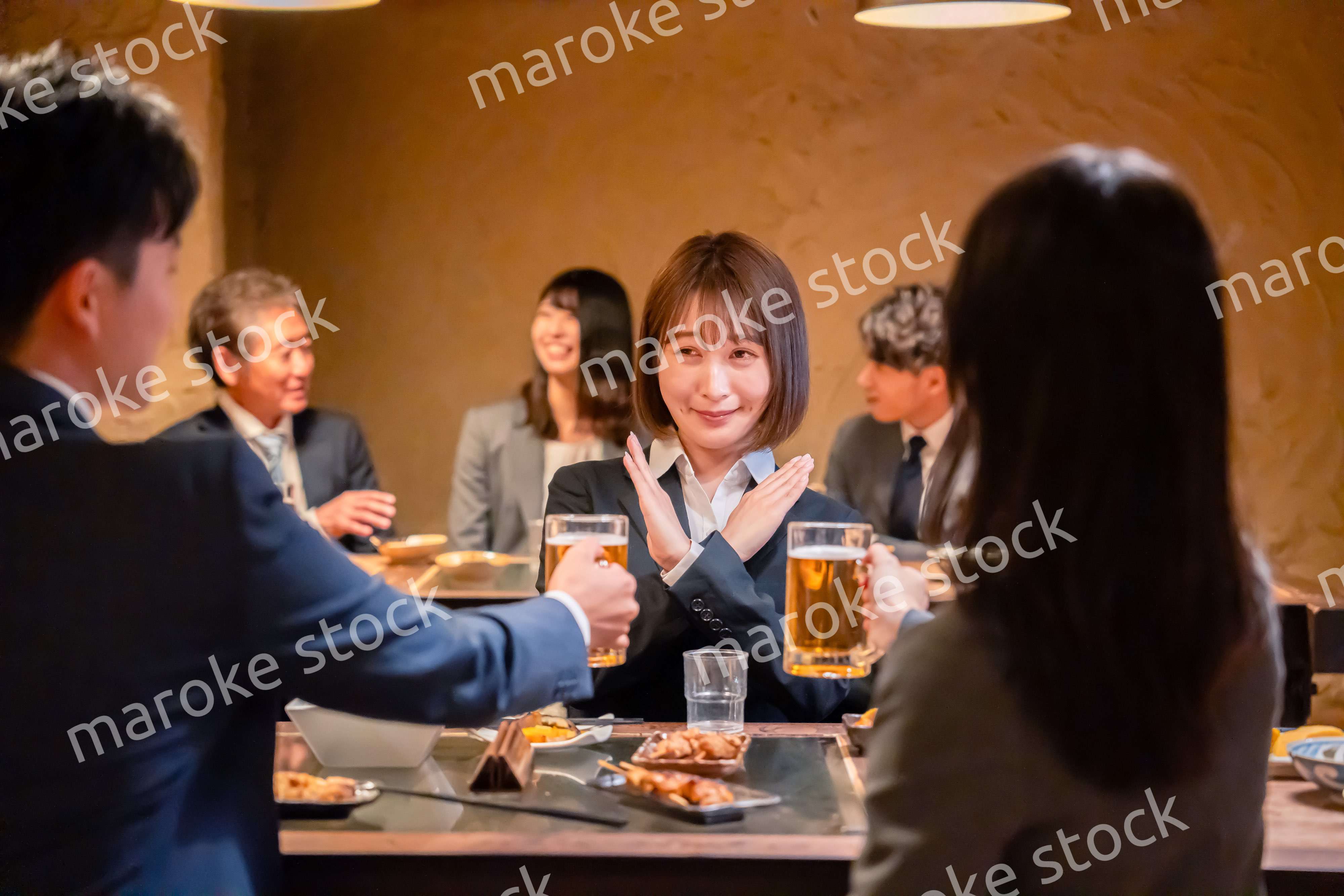 居酒屋で先輩社員にアルコールを勧められて断る女性社員