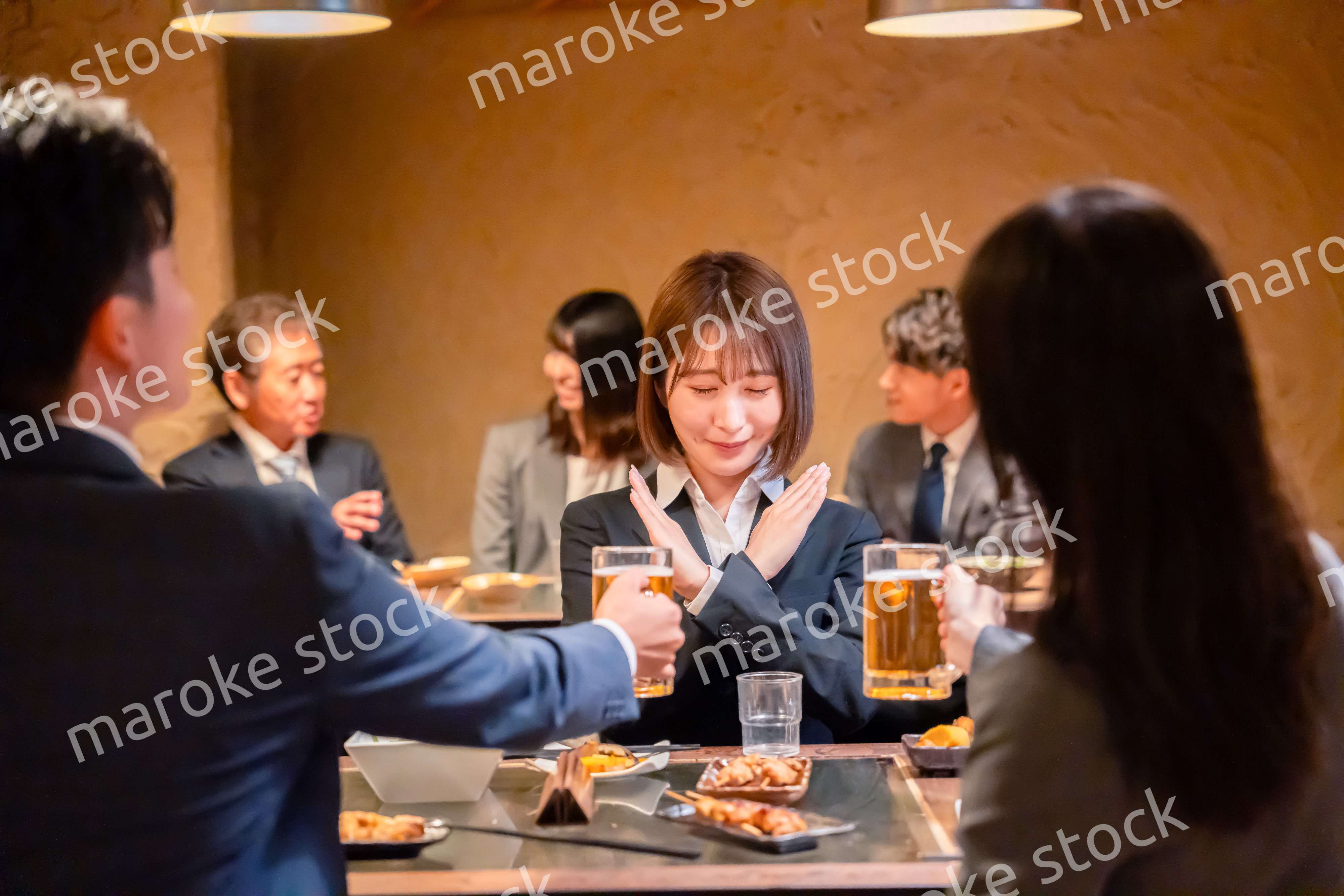 居酒屋で先輩社員にアルコールを勧められて断る女性社員