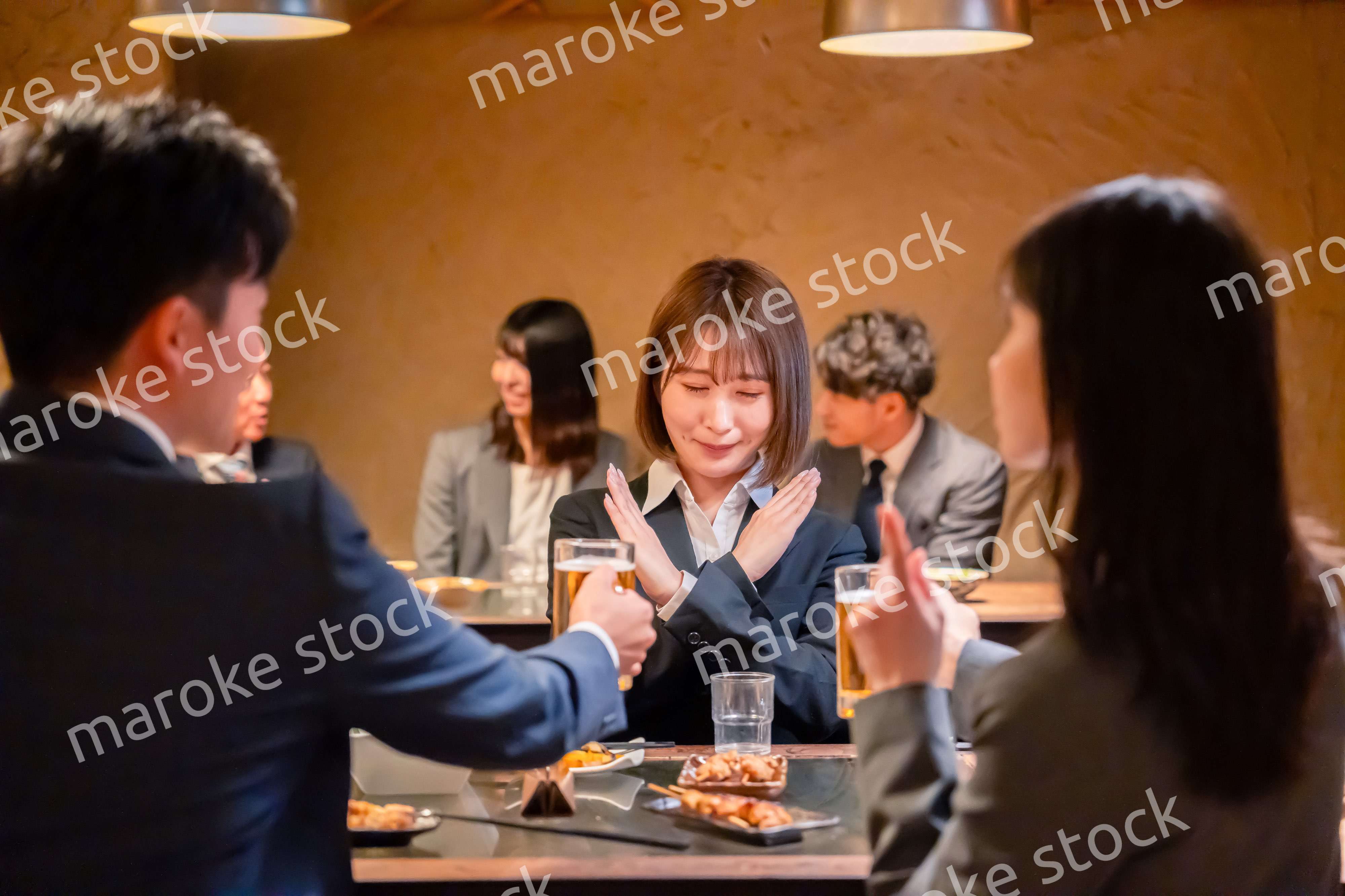 居酒屋で先輩社員にアルコールを勧められて断る女性社員