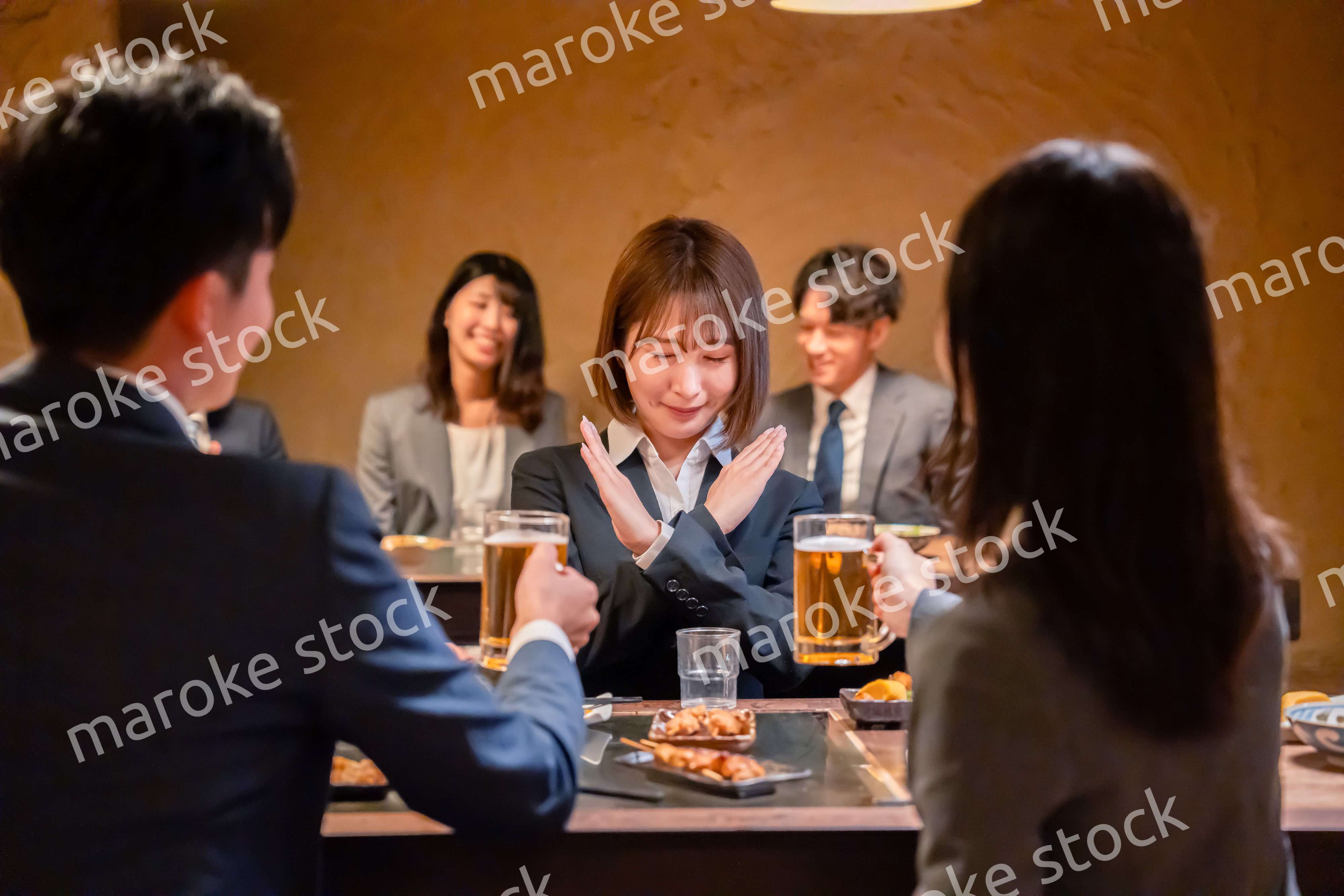 居酒屋で先輩社員にアルコールを勧められて断る女性社員