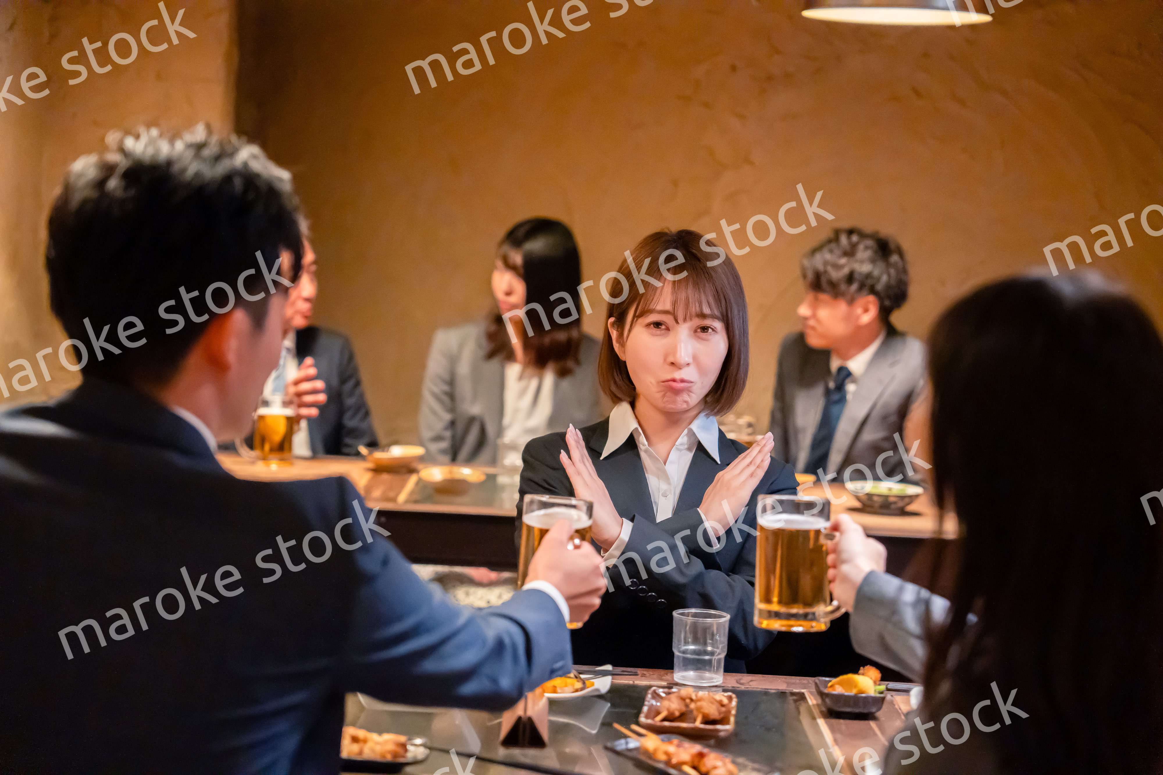 居酒屋で先輩社員にアルコールを勧められて断る女性社員