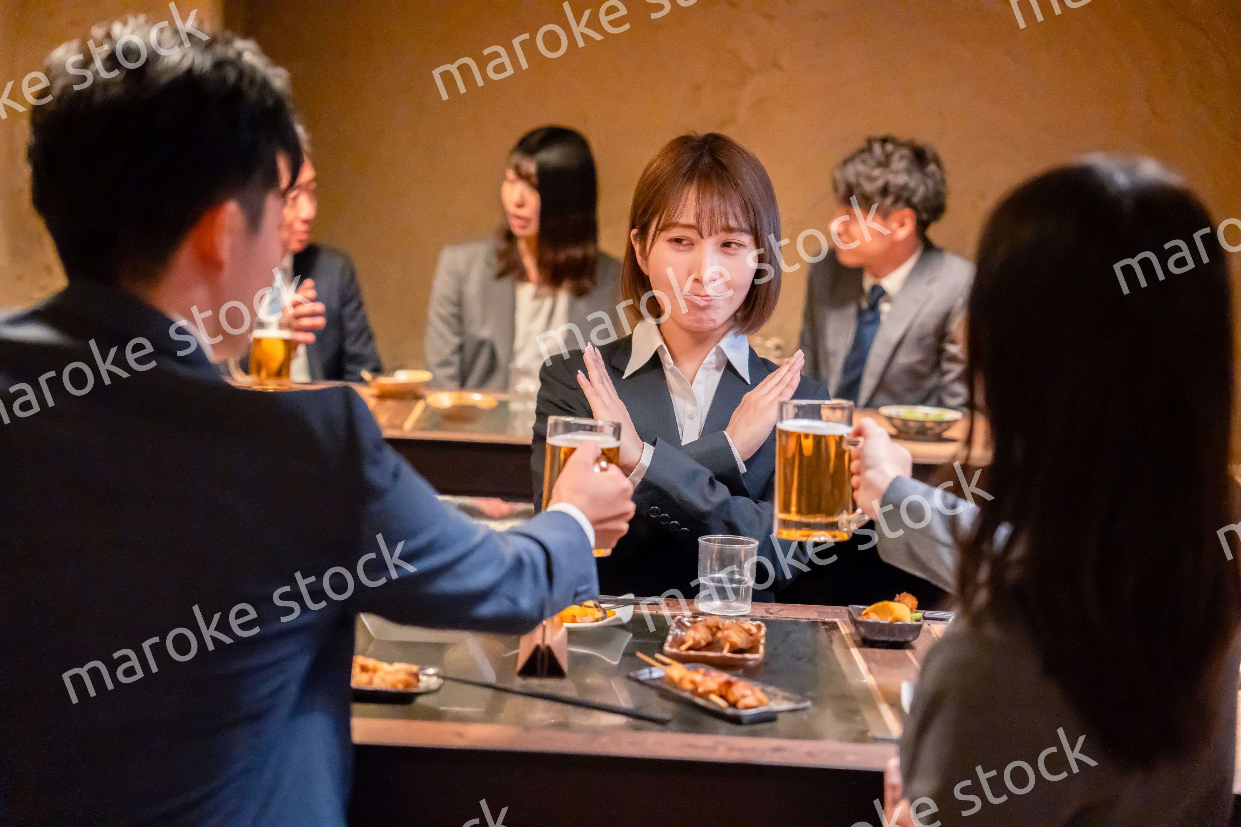 居酒屋で先輩社員にアルコールを勧められて断る女性社員