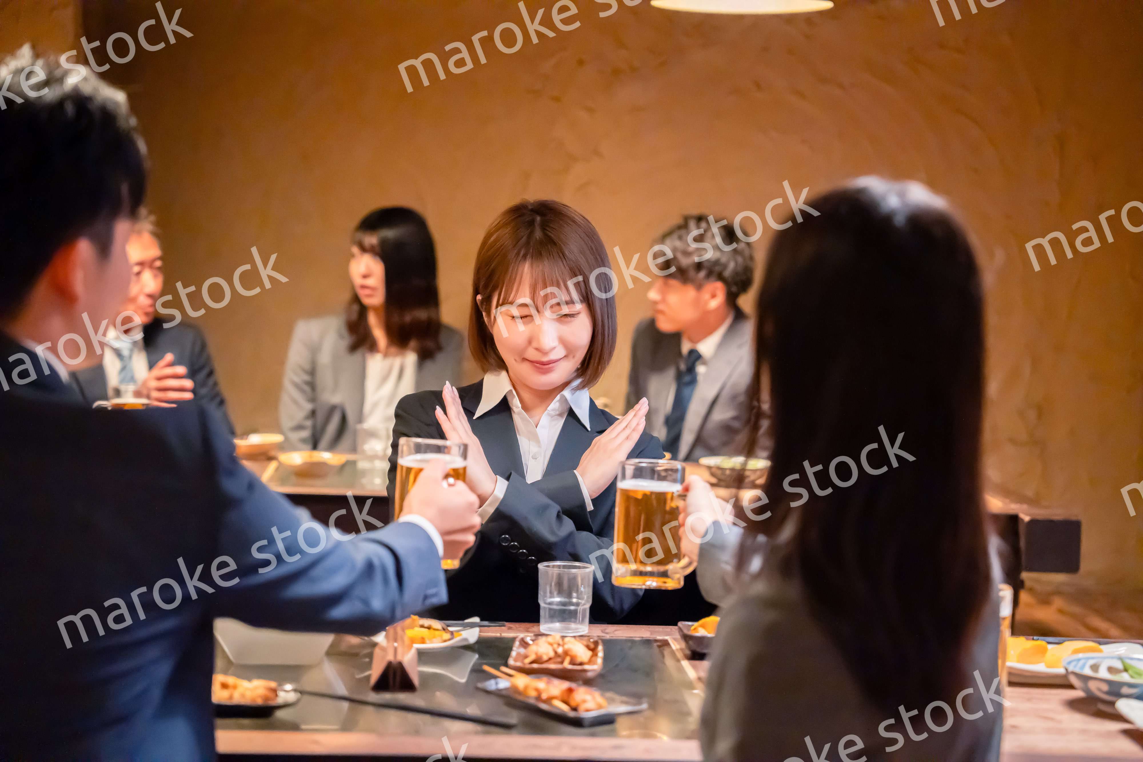 居酒屋で先輩社員にアルコールを勧められて断る女性社員