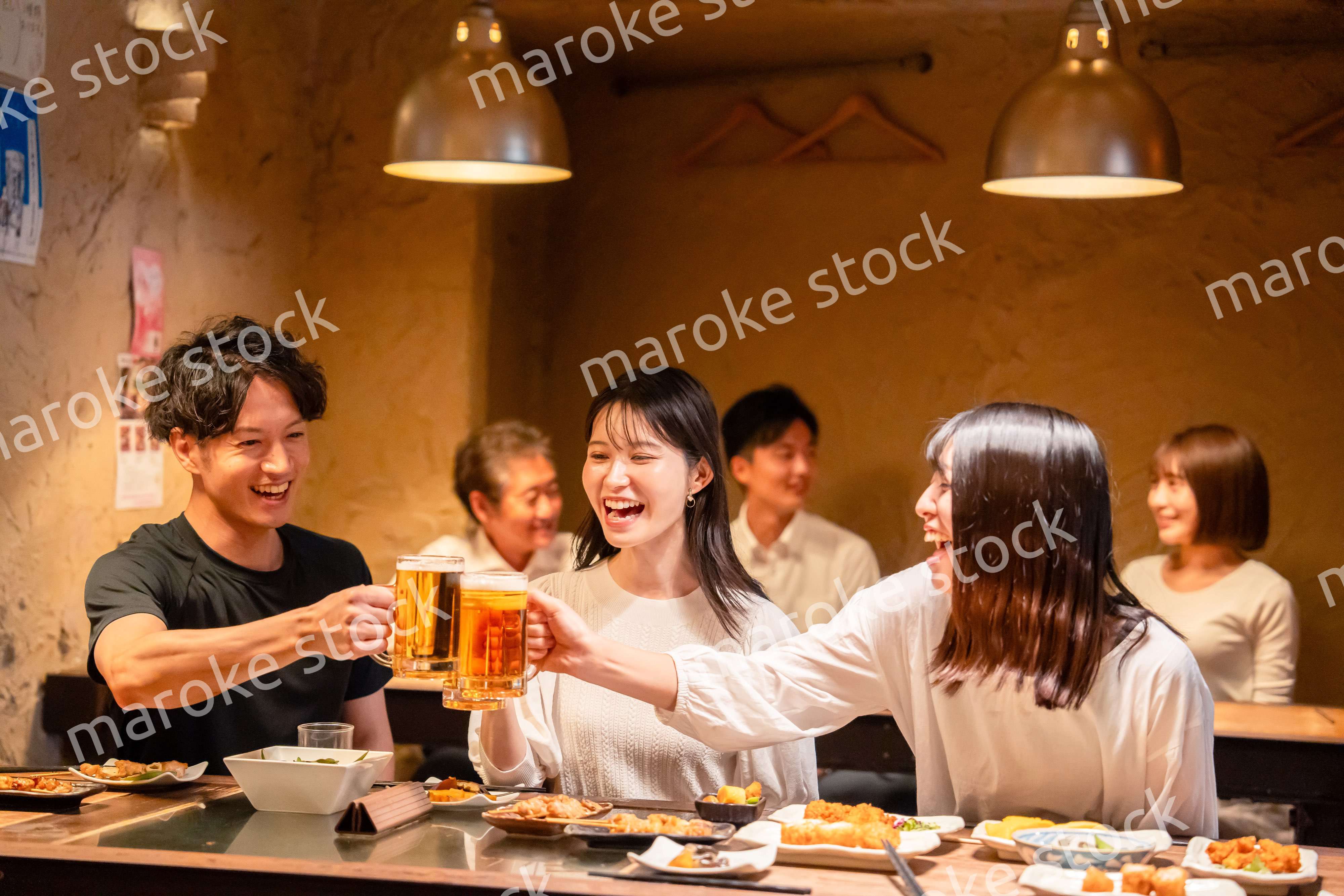 居酒屋でお酒を飲む若い男女