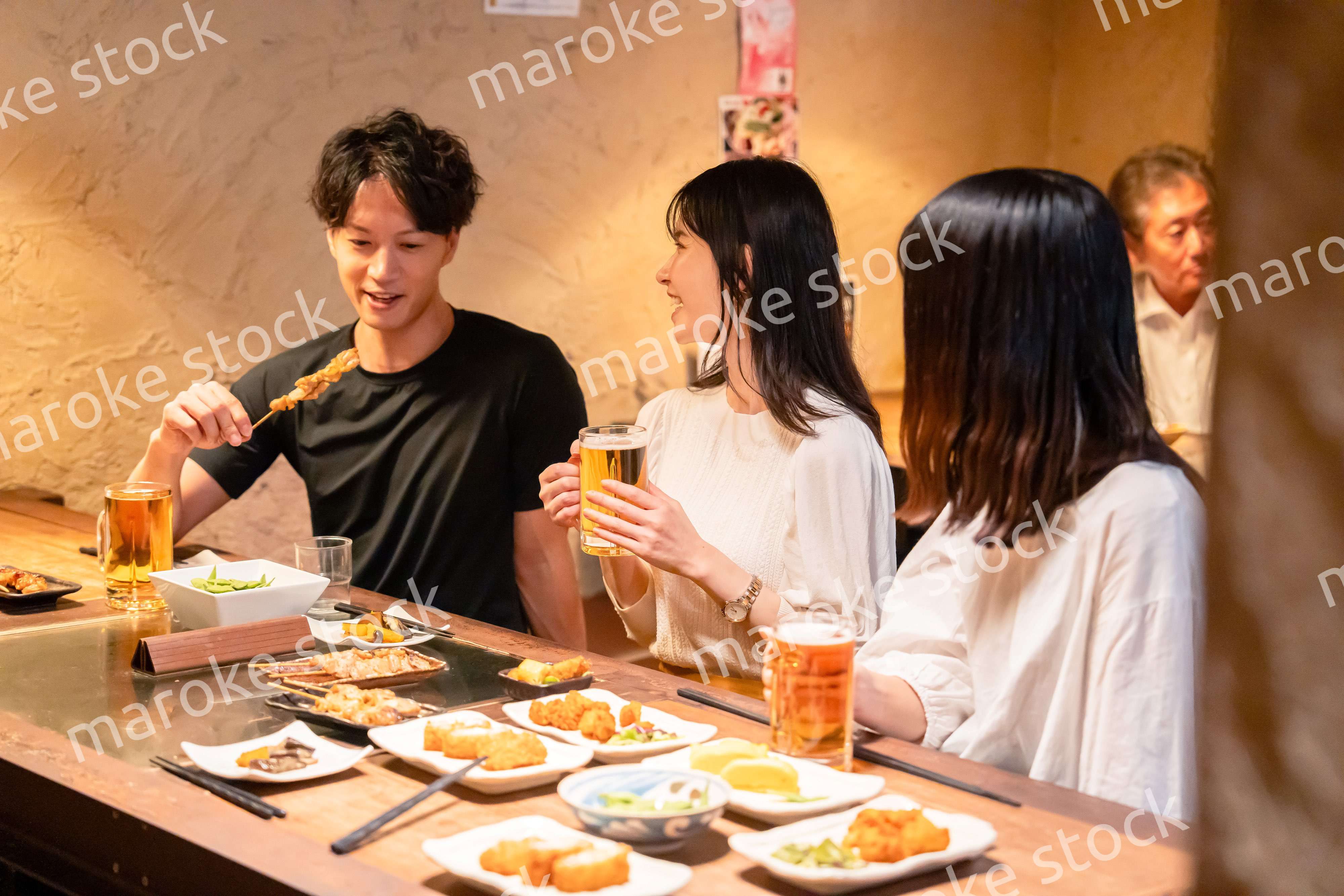 居酒屋でお酒を飲む若い男女