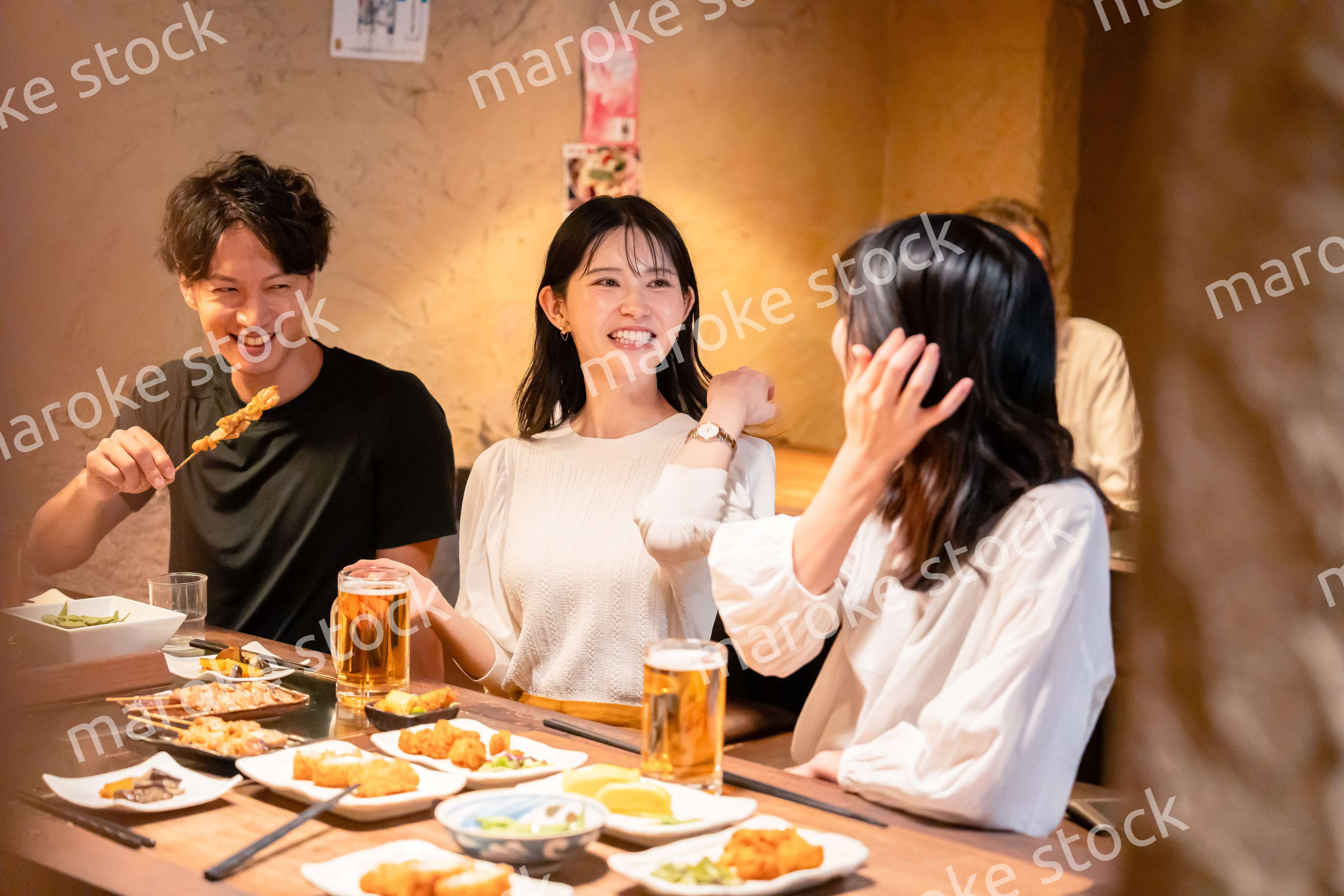 居酒屋でお酒を飲む若い男女