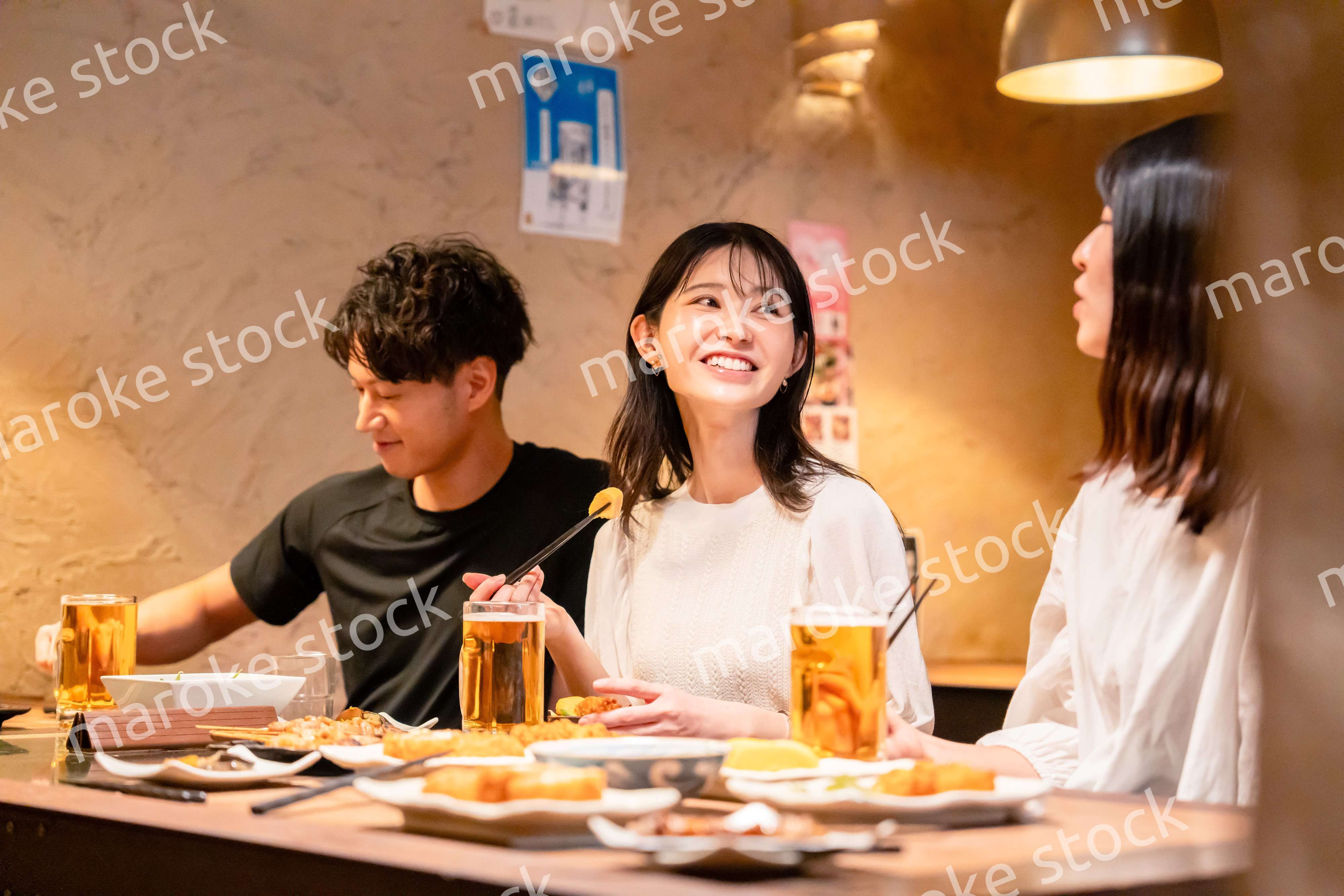 居酒屋でお酒を飲む若い男女