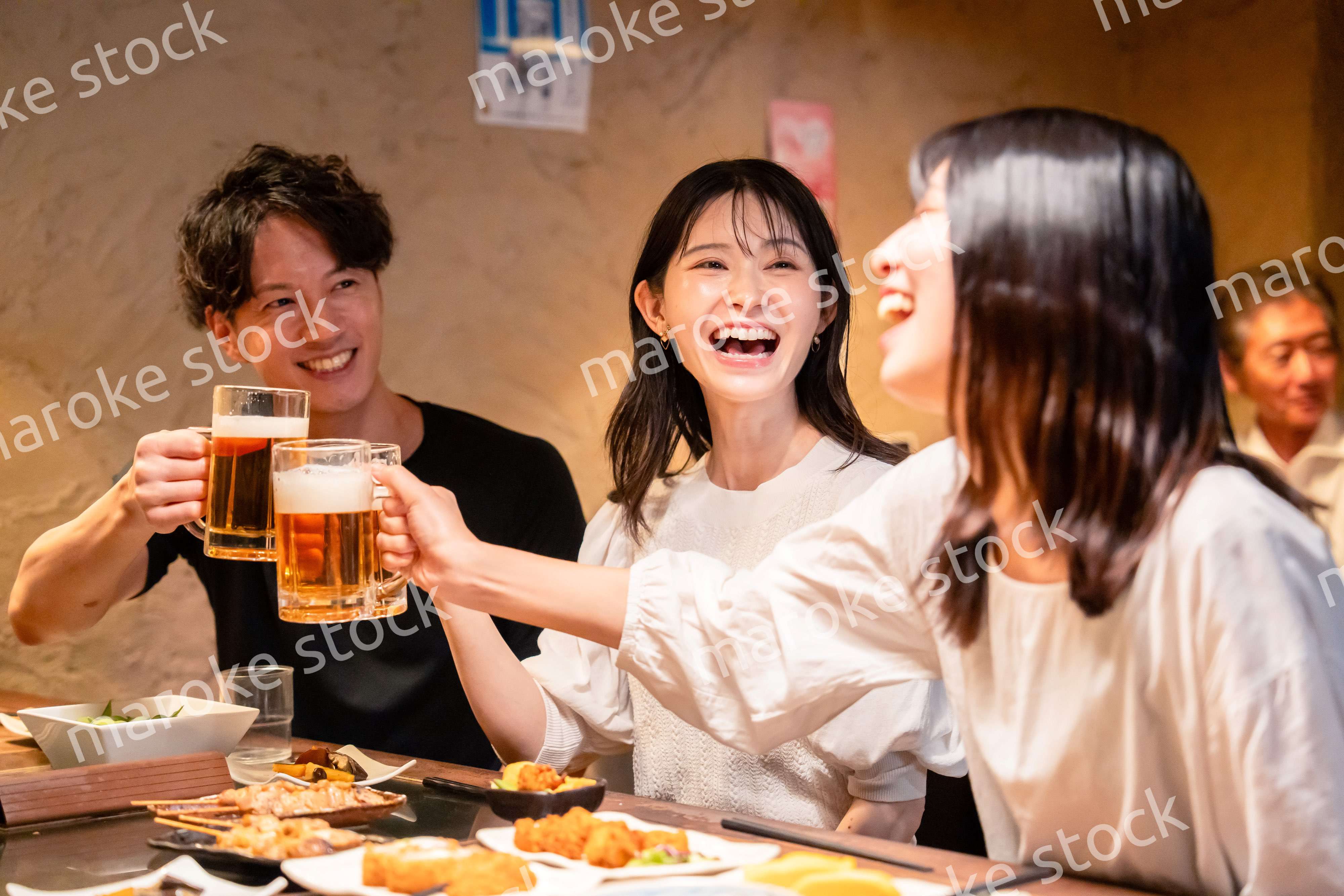 居酒屋でお酒を飲む若い男女