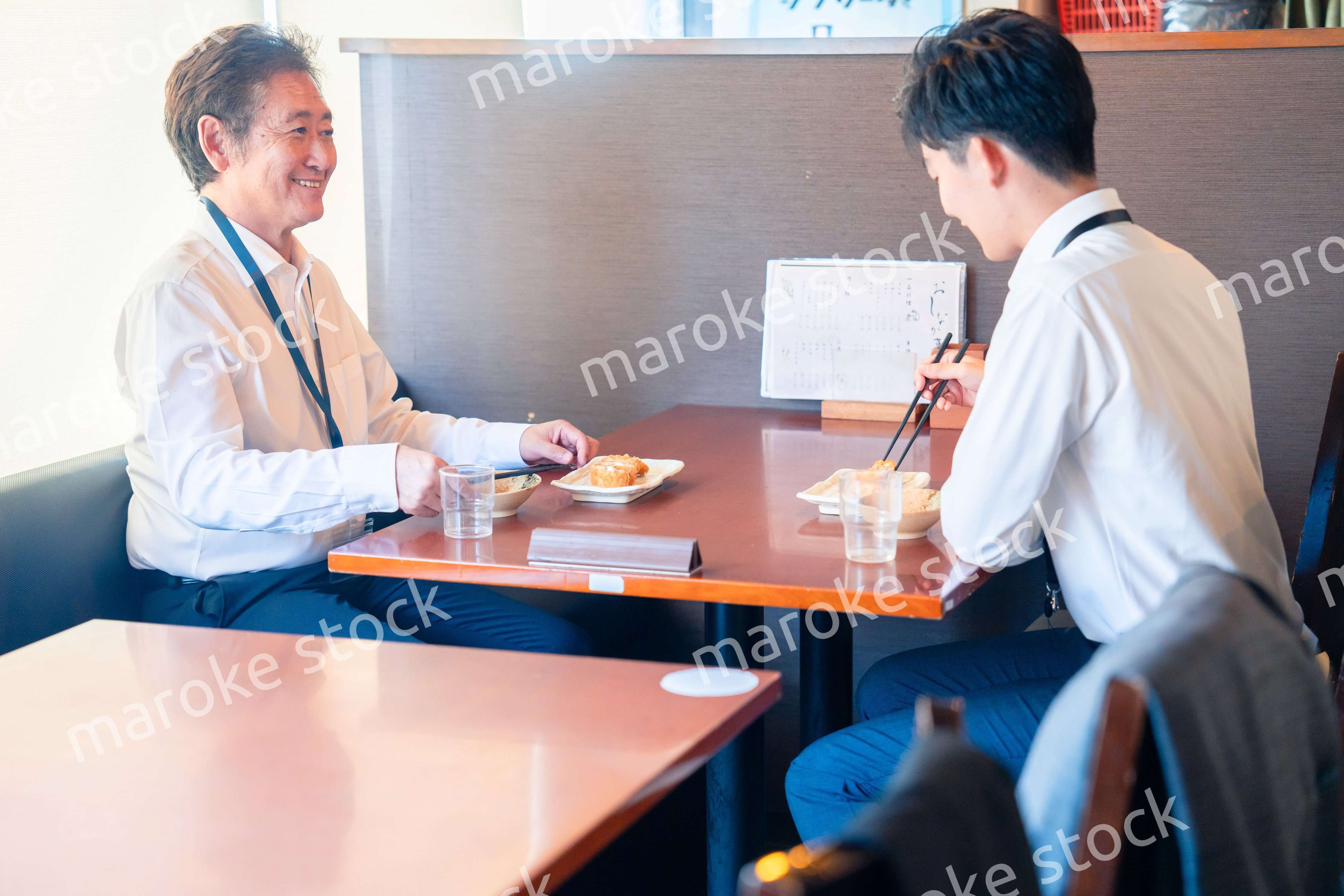 レストランでお昼ごはんを食べる二人のビジネスマン