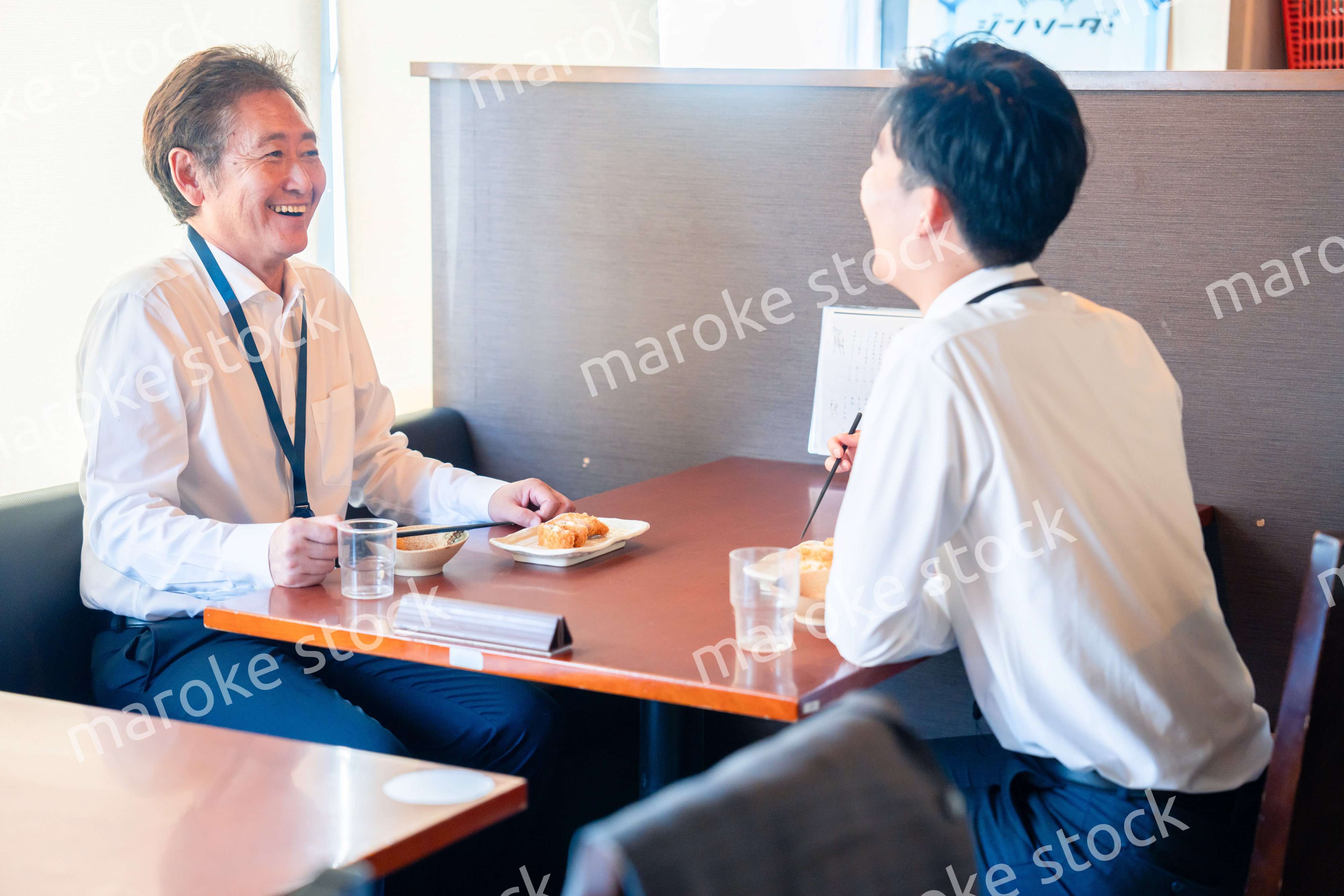 レストランでお昼ごはんを食べる二人のビジネスマン