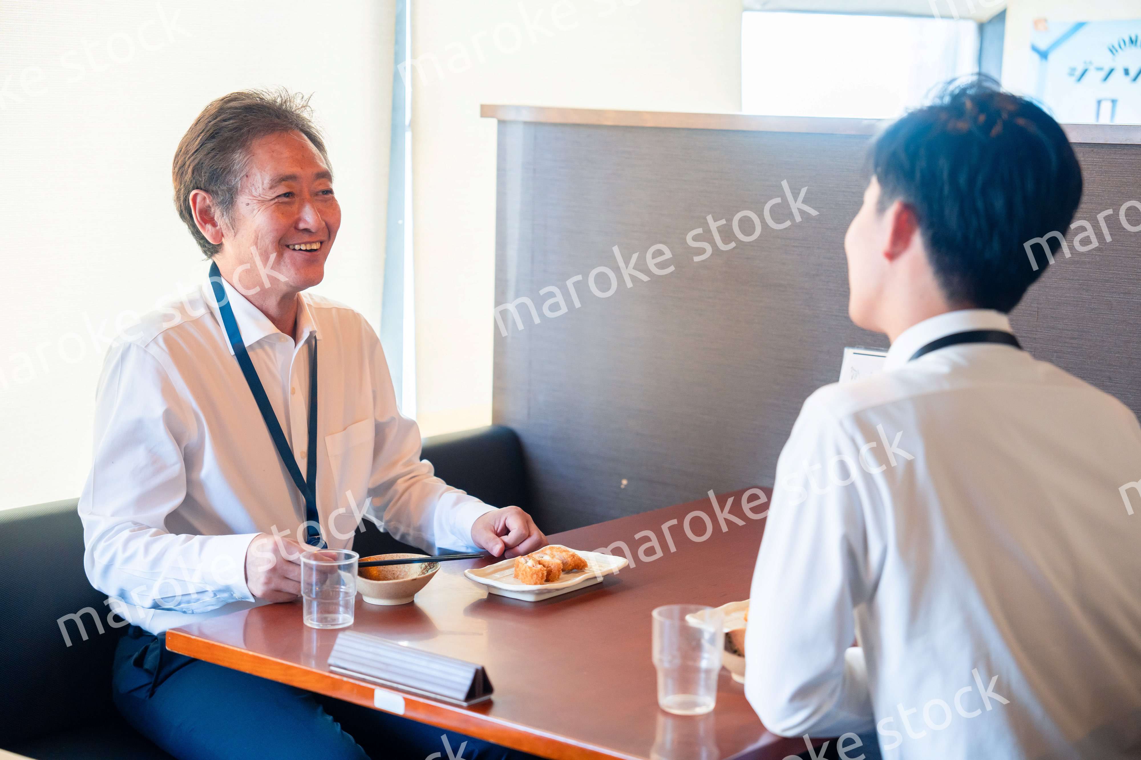 レストランでお昼ごはんを食べる二人のビジネスマン