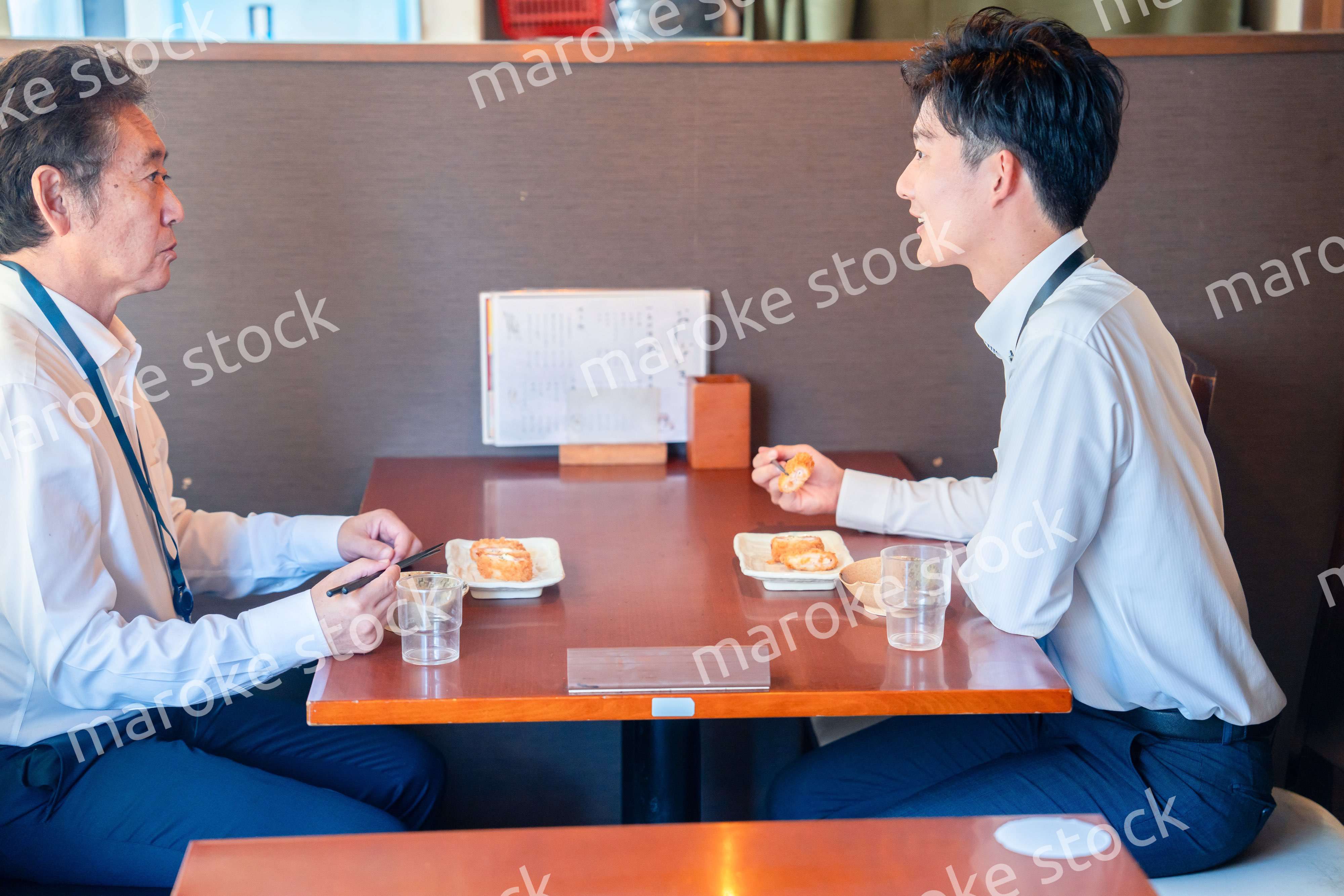 レストランでお昼ごはんを食べる二人のビジネスマン