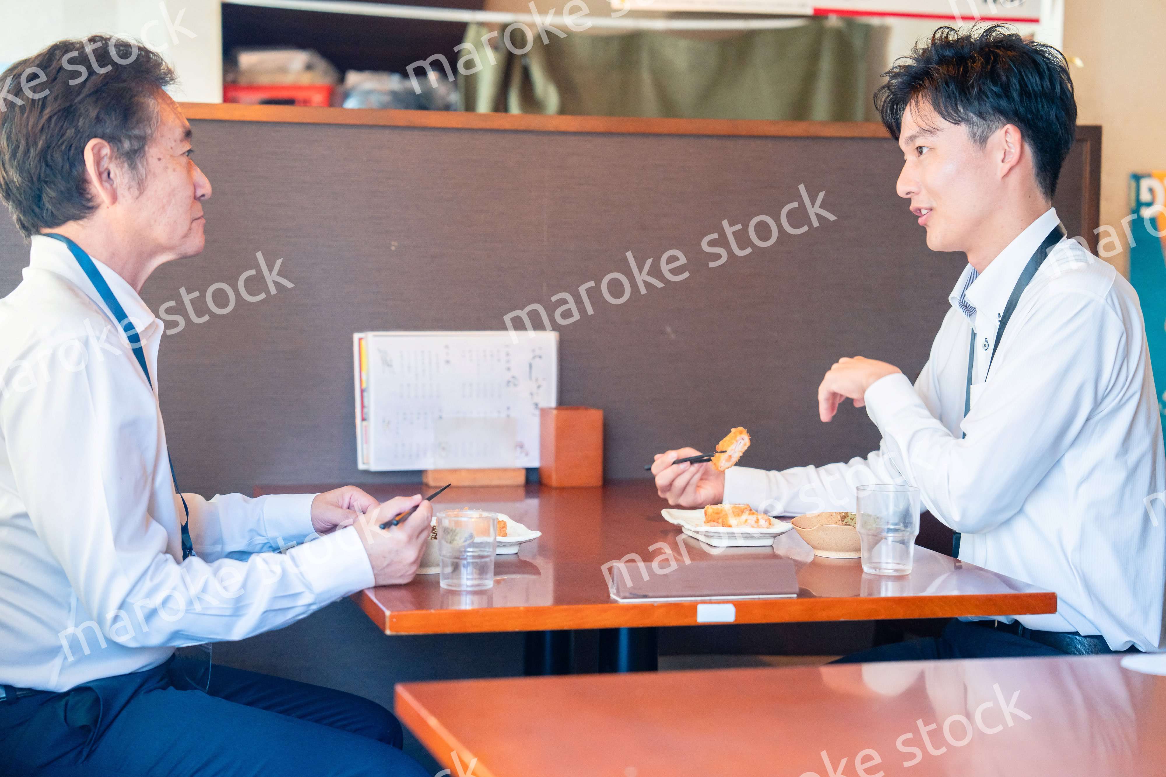 レストランでお昼ごはんを食べる二人のビジネスマン