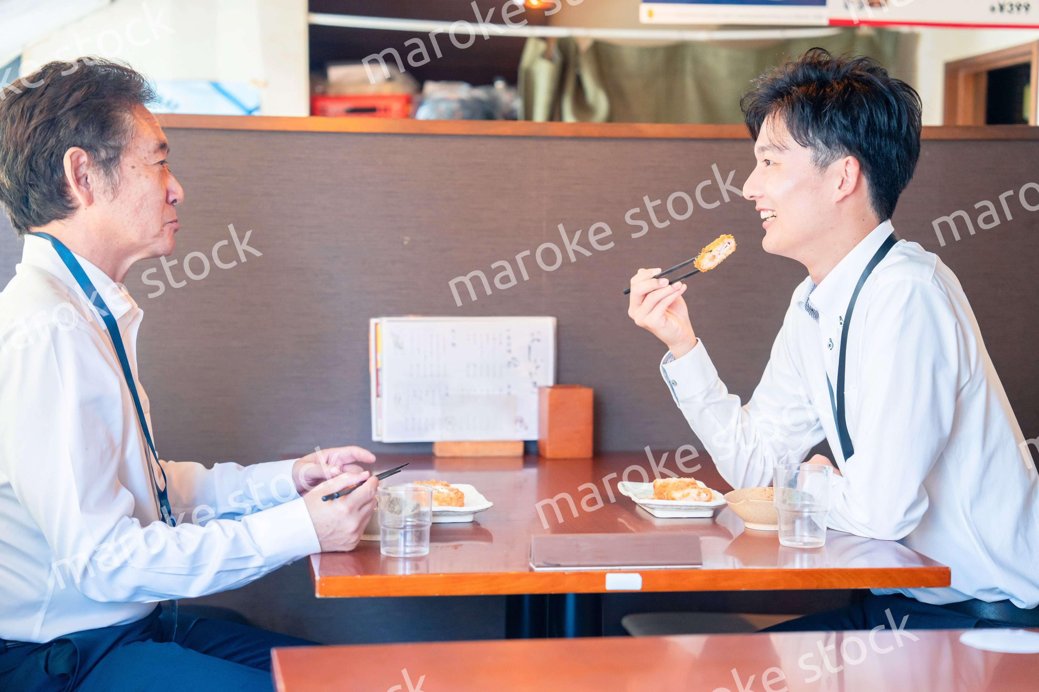 レストランでお昼ごはんを食べる二人のビジネスマン