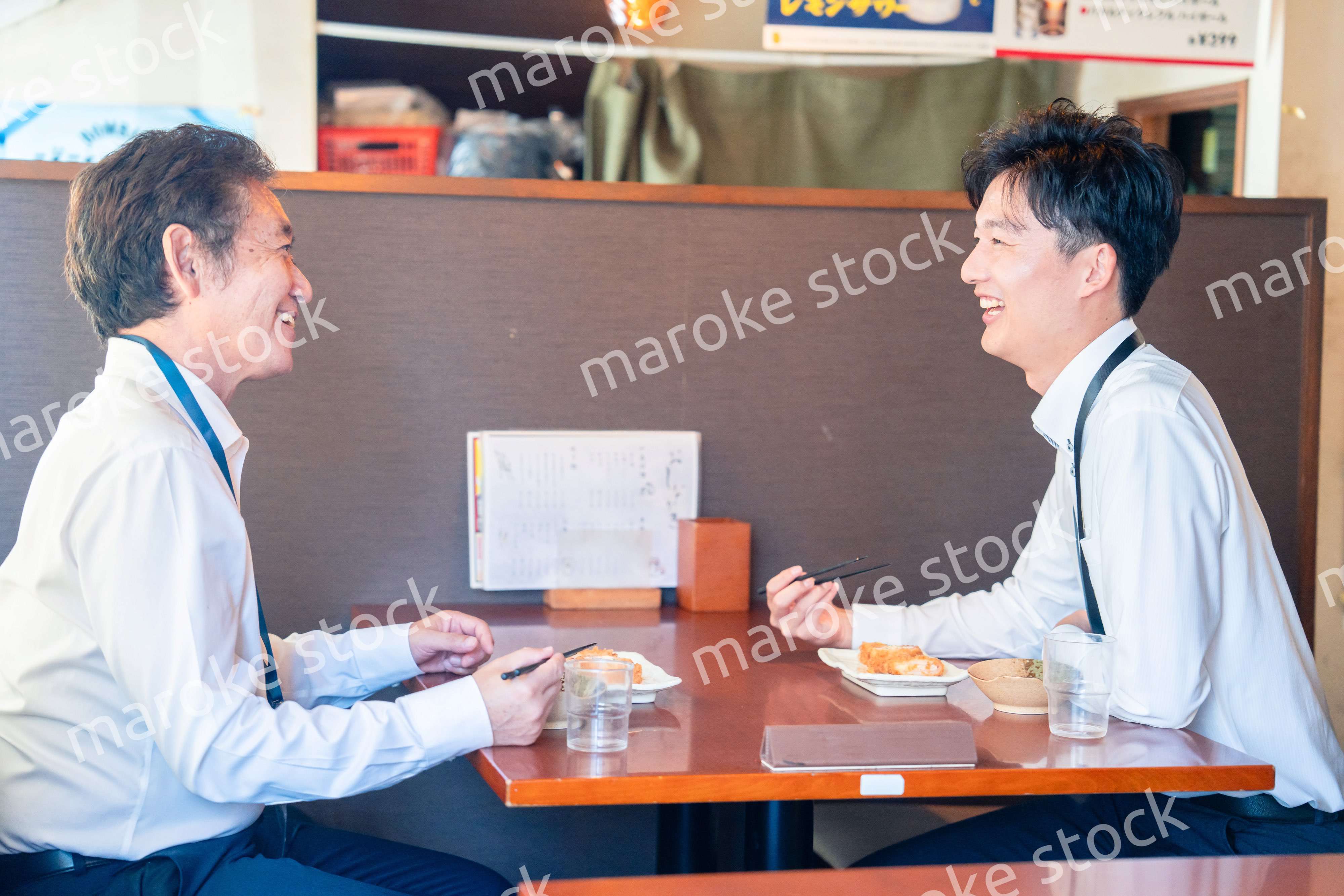 レストランでお昼ごはんを食べる二人のビジネスマン