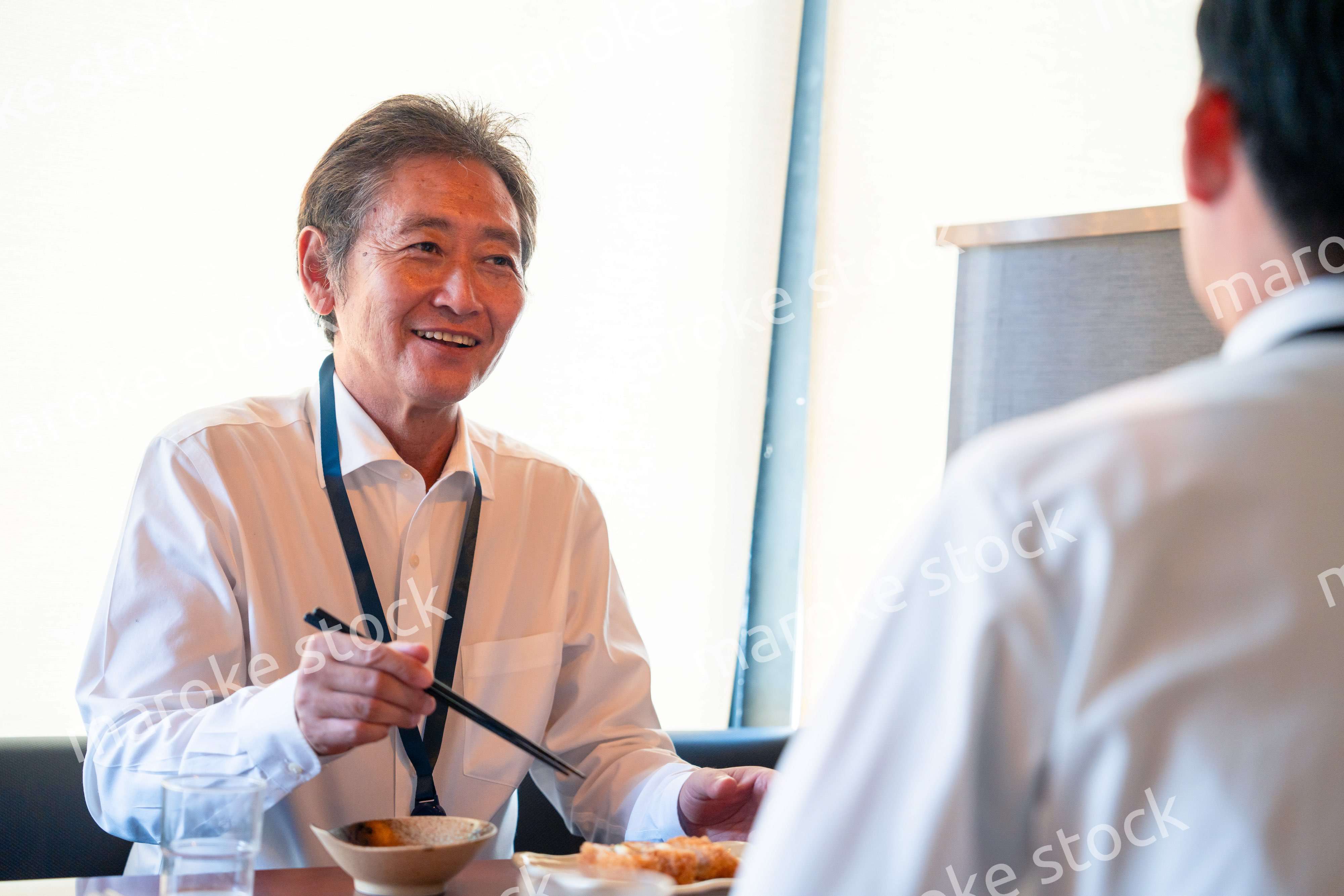 レストランでお昼ごはんを食べる二人のビジネスマン