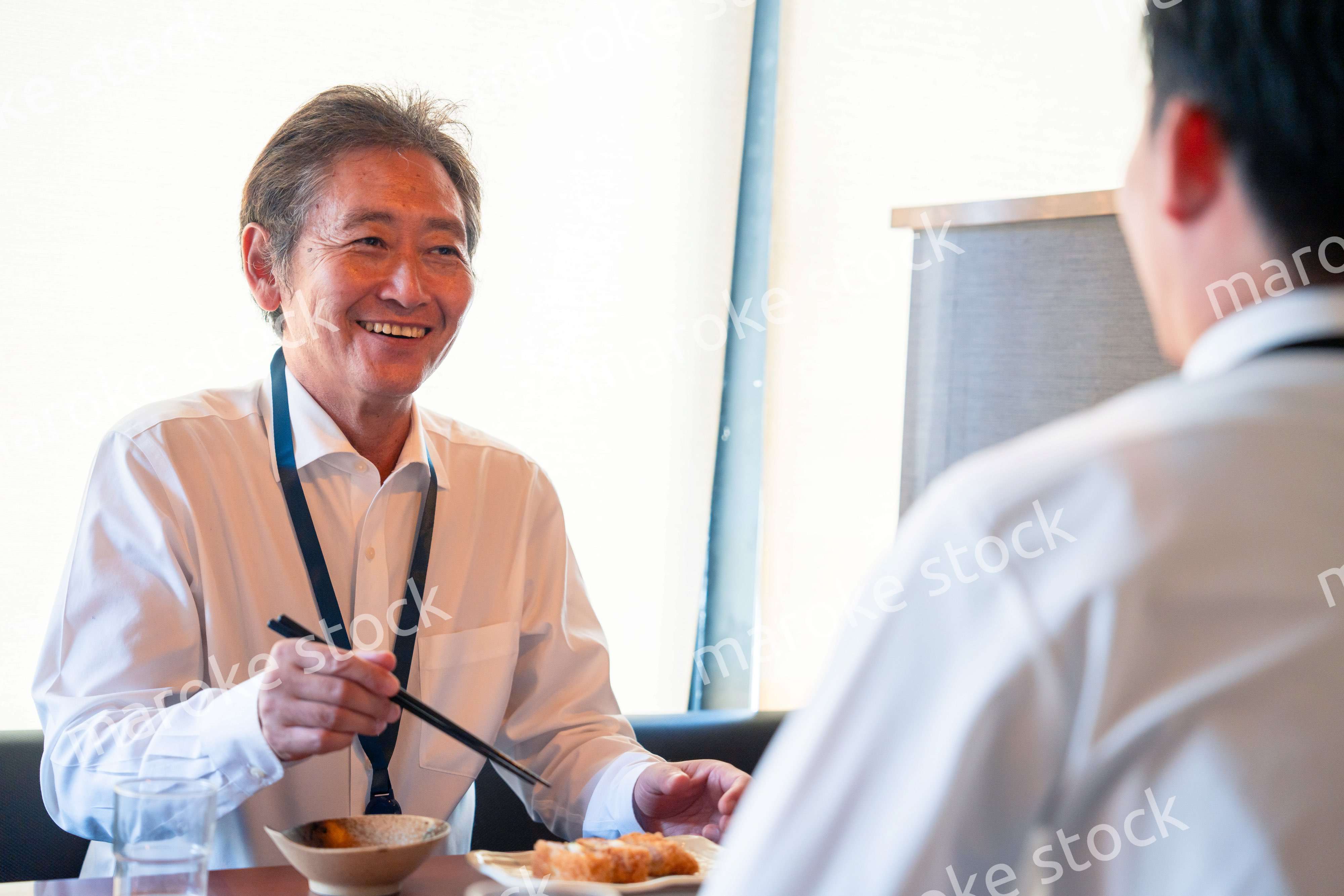 レストランでお昼ごはんを食べる二人のビジネスマン