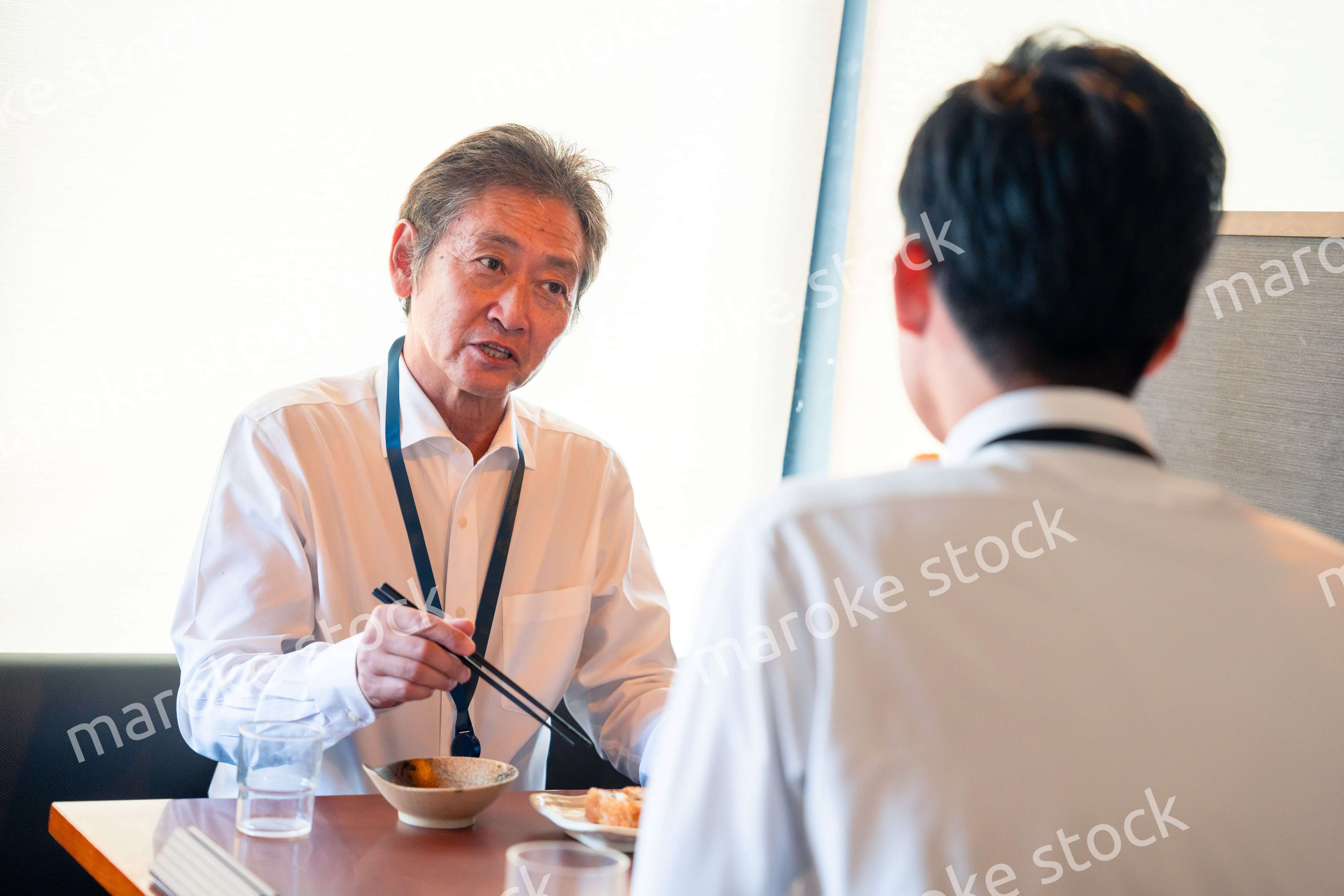 レストランでお昼ごはんを食べる二人のビジネスマン