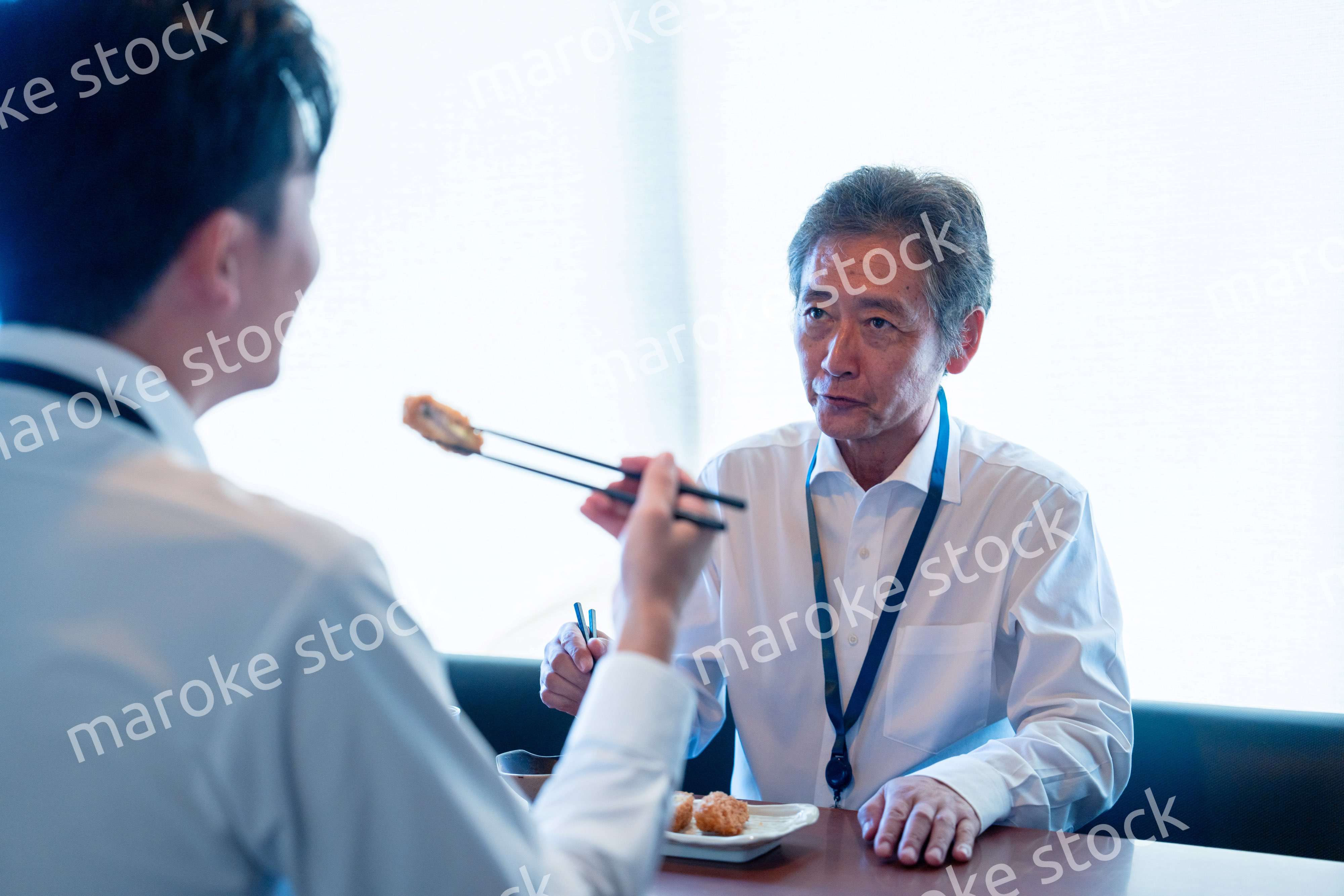 レストランでお昼ごはんを食べる二人のビジネスマン