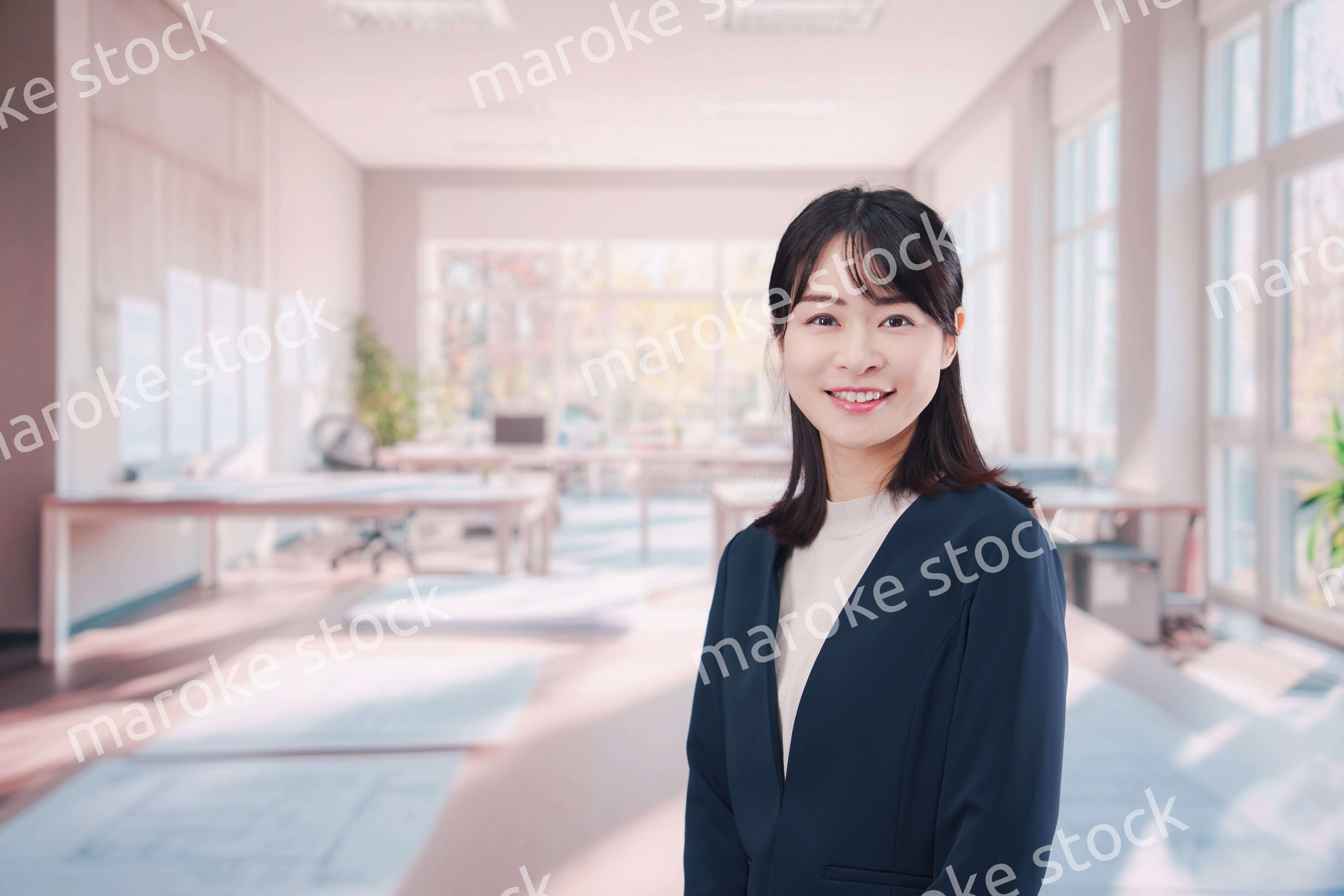 オフィスカジュアルでオフィスに立つ若い女性