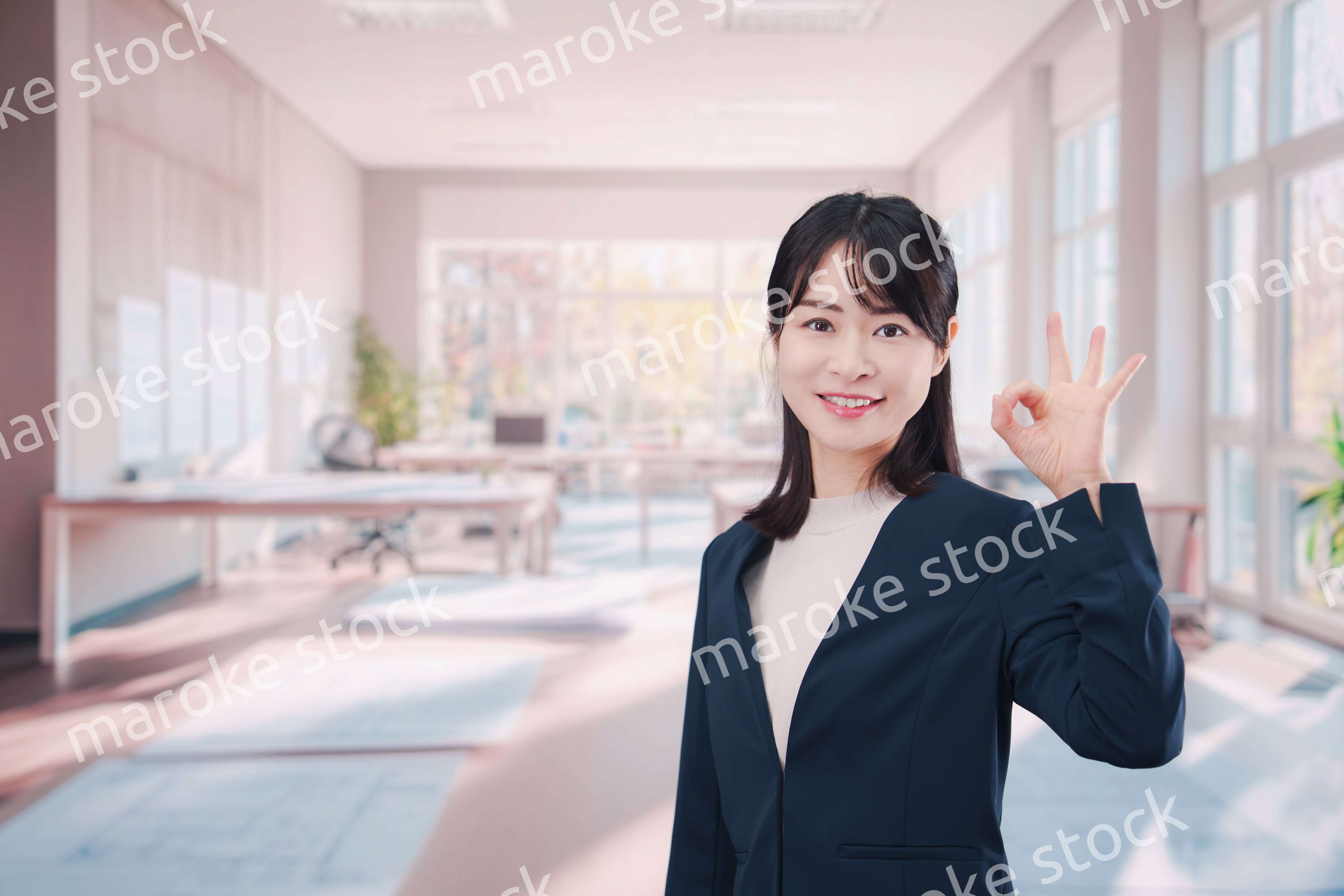 オフィスカジュアルでオフィスに立つ若い女性