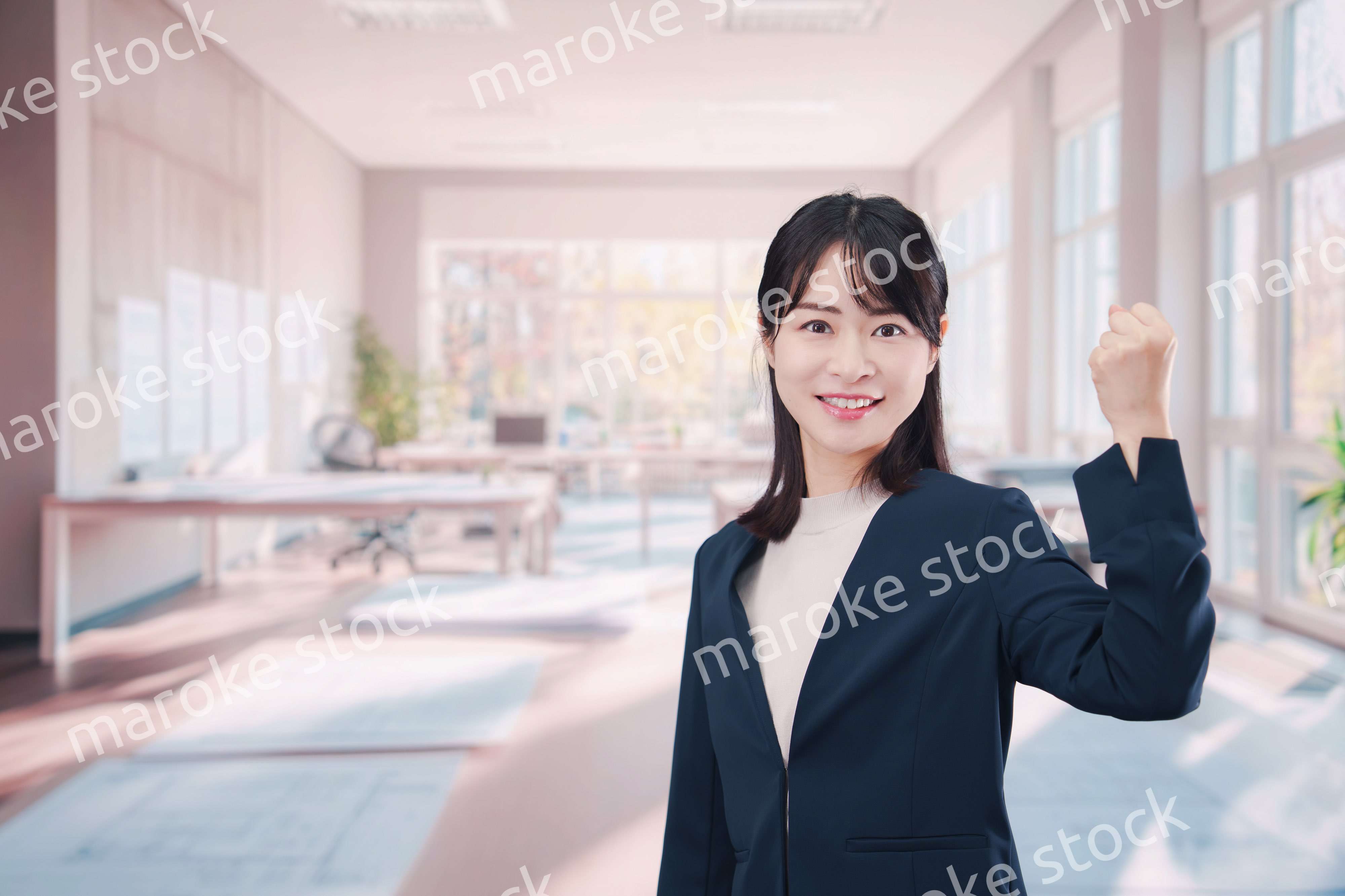 オフィスカジュアルでオフィスに立つ若い女性