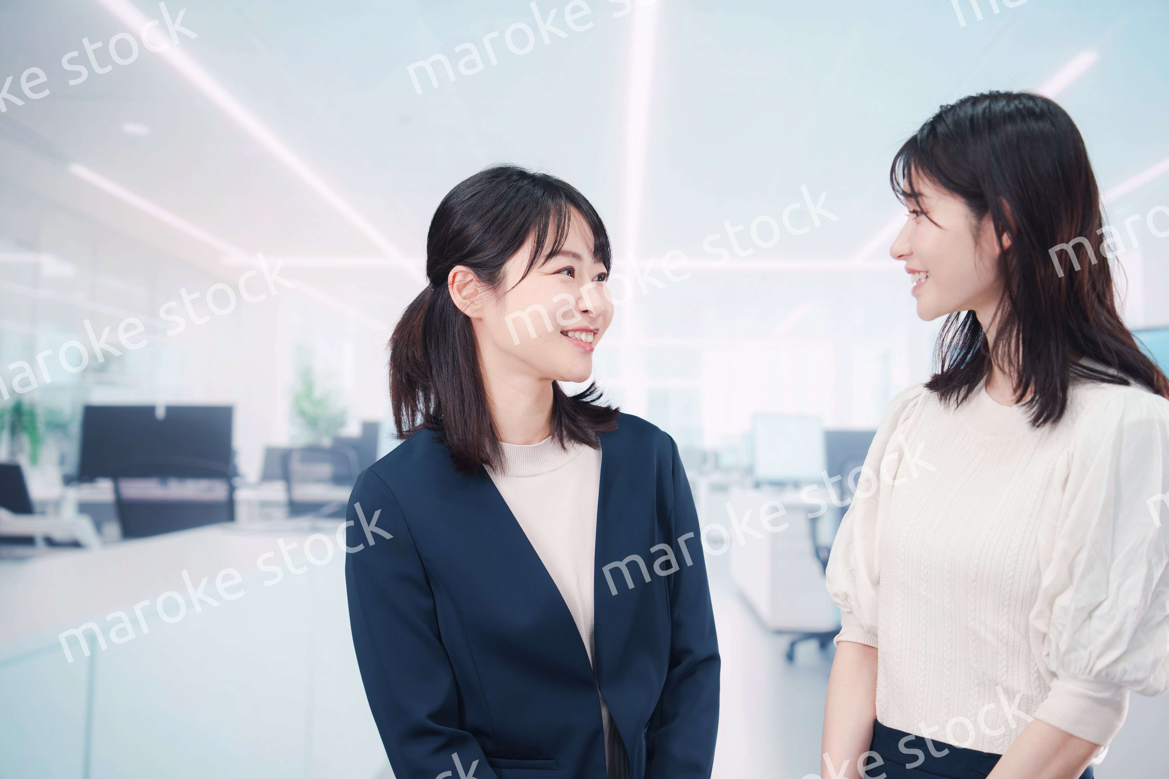 オフィスで会話をする二人のビジネスウーマン