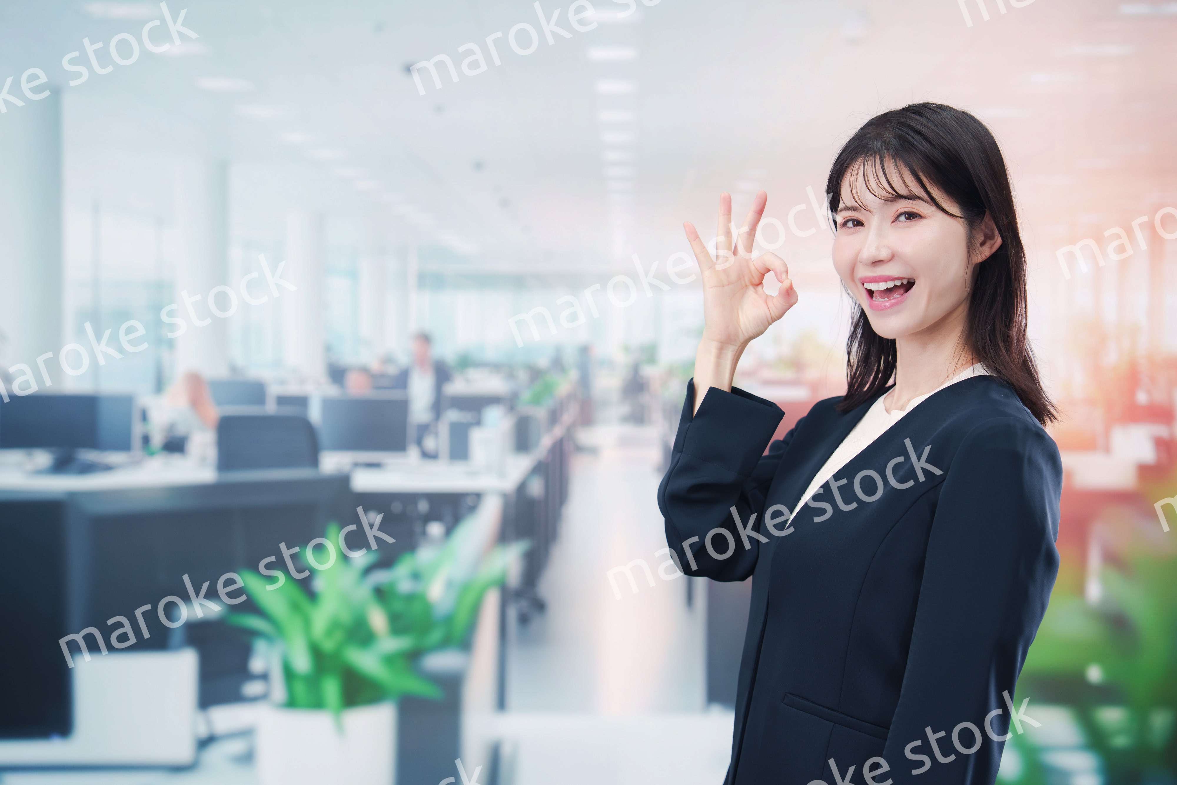 笑顔でオフィス勤務をする若い女性