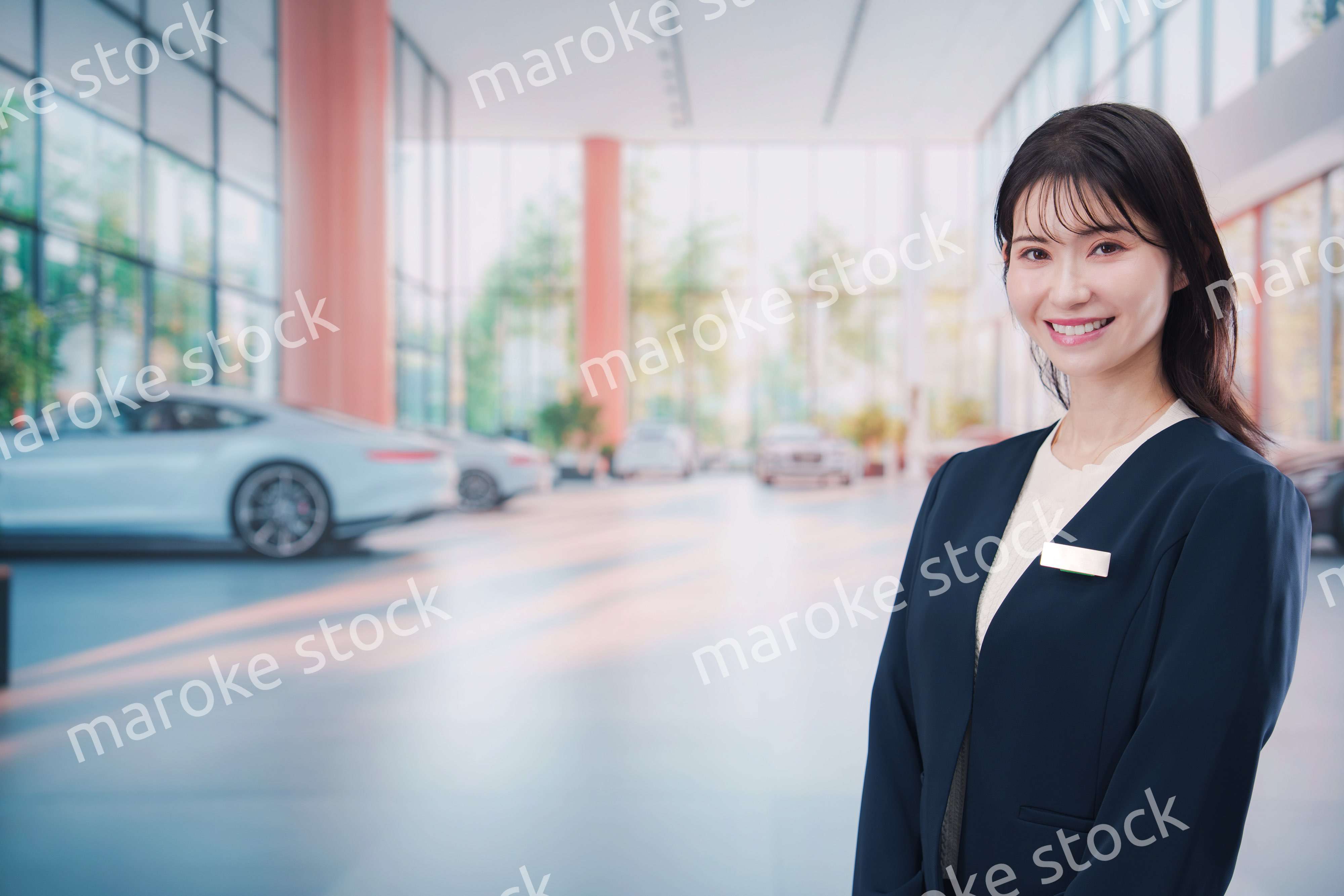 カーディーラーで接客をする若い女性