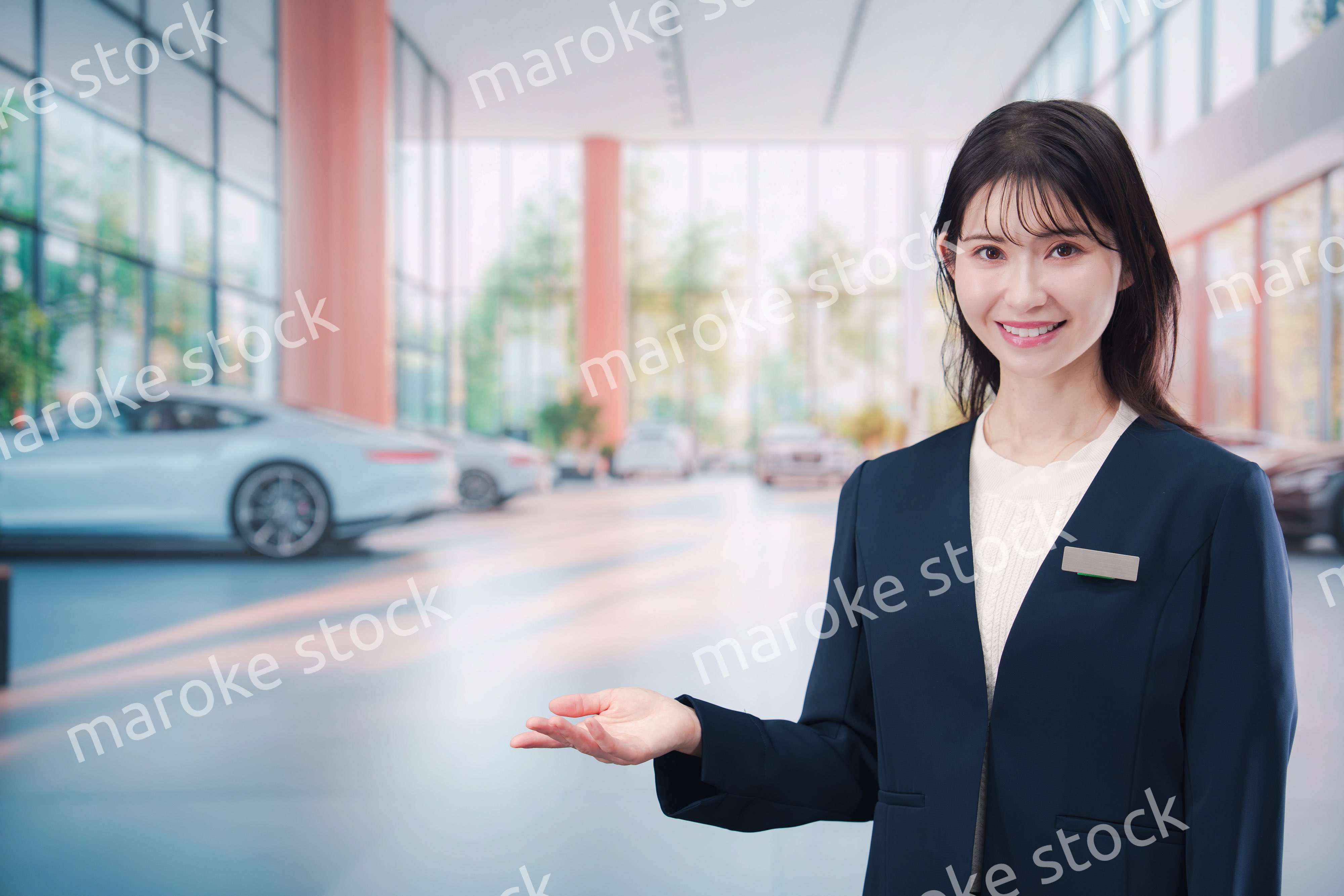 カーディーラーで接客をする若い女性