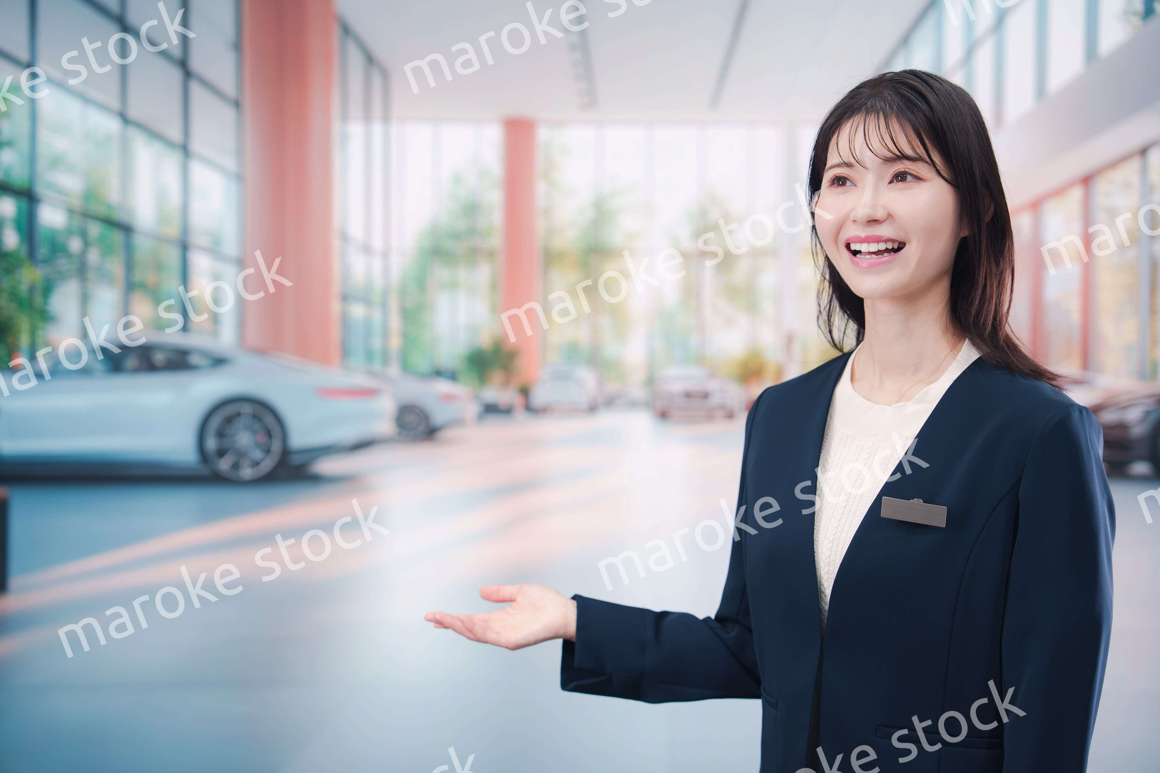 カーディーラーで接客をする若い女性
