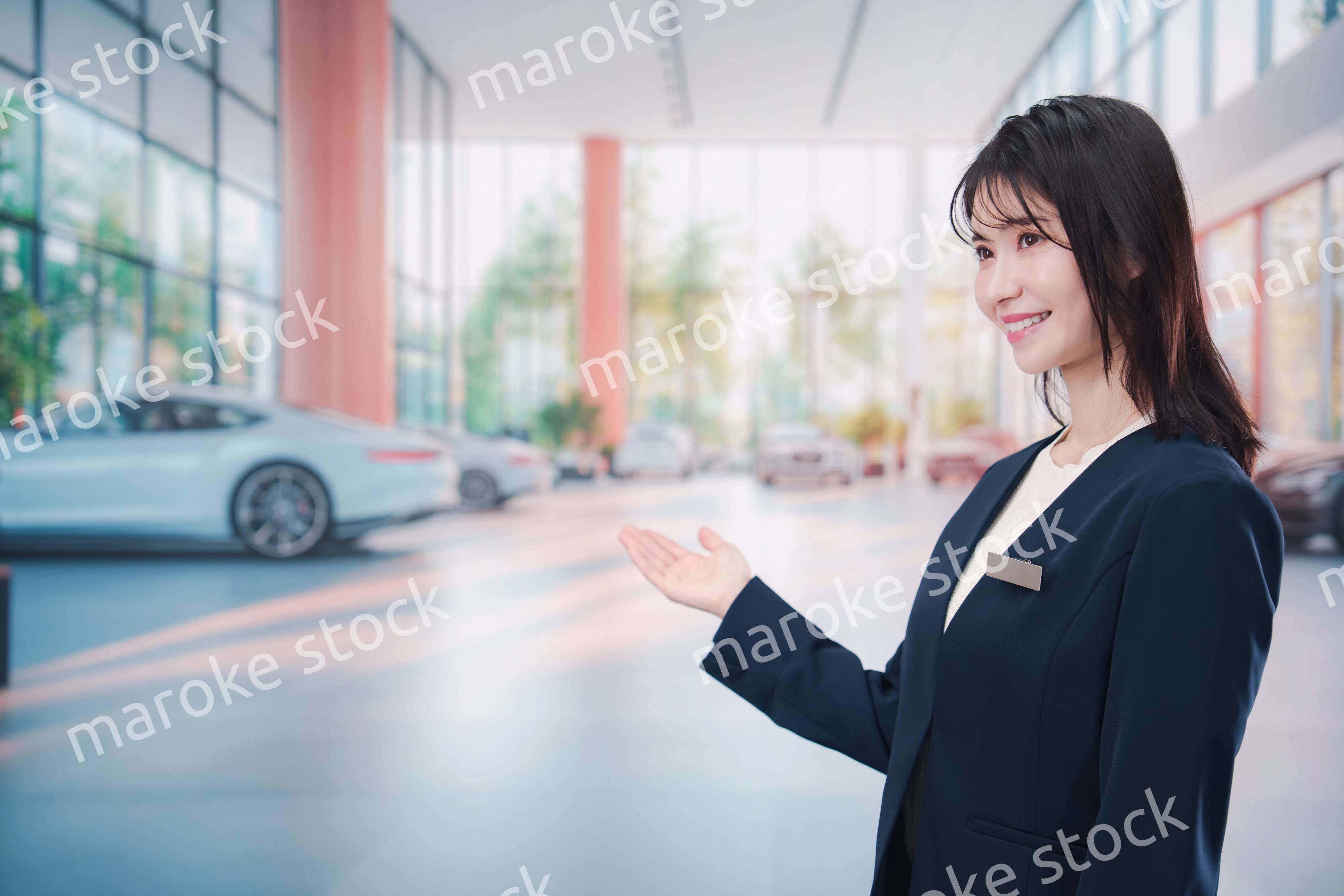 カーディーラーで接客をする若い女性