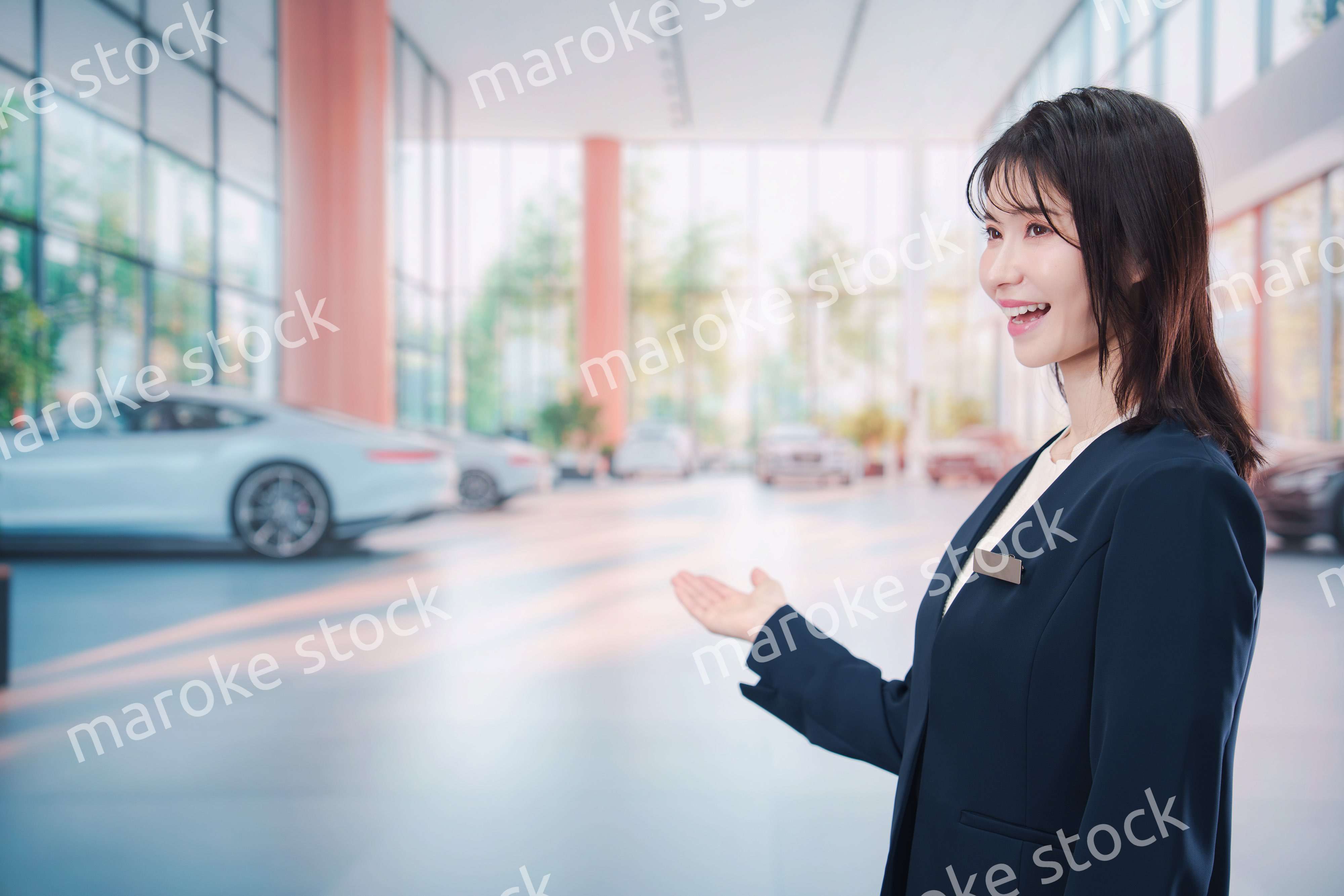 カーディーラーで接客をする若い女性