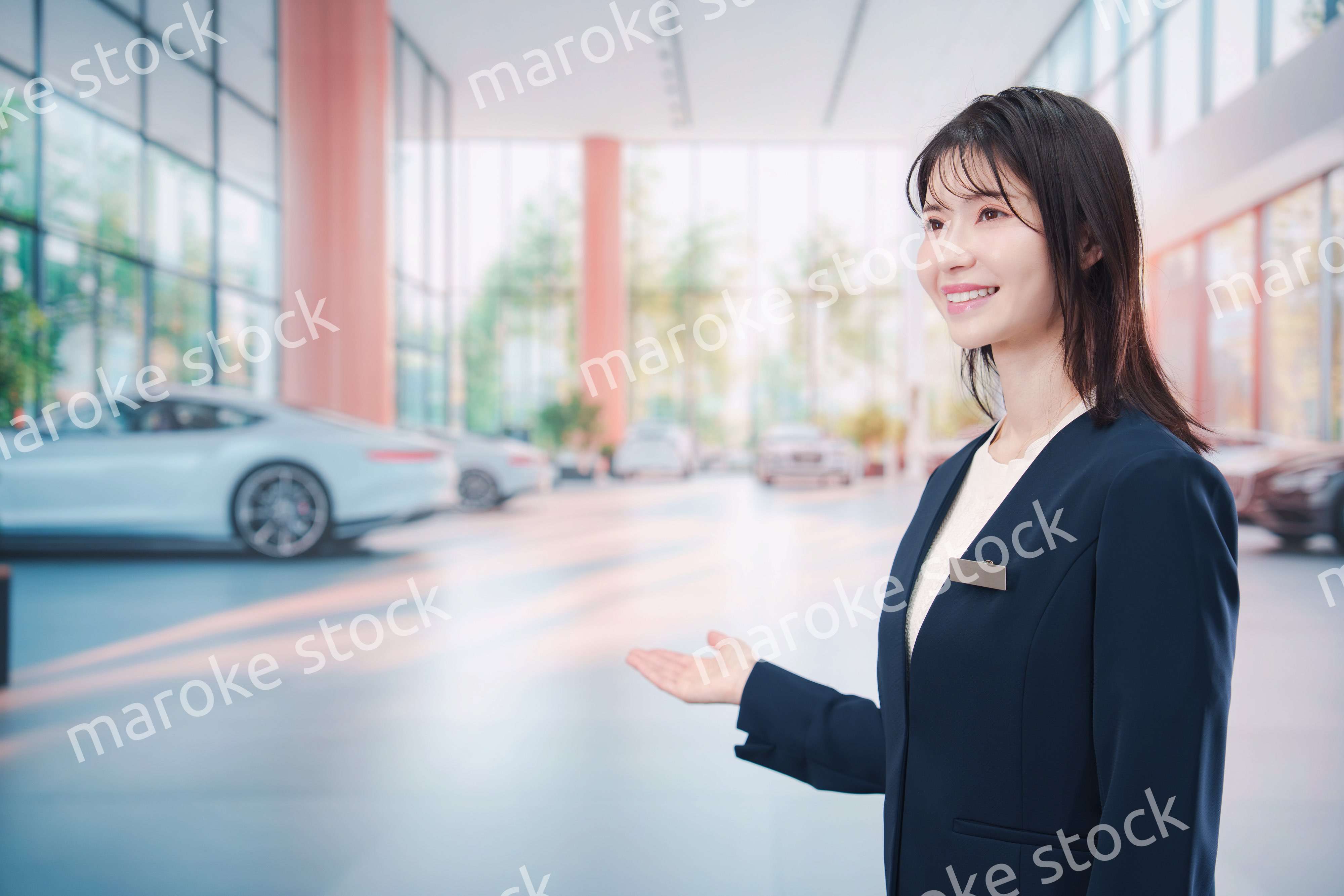 カーディーラーで接客をする若い女性