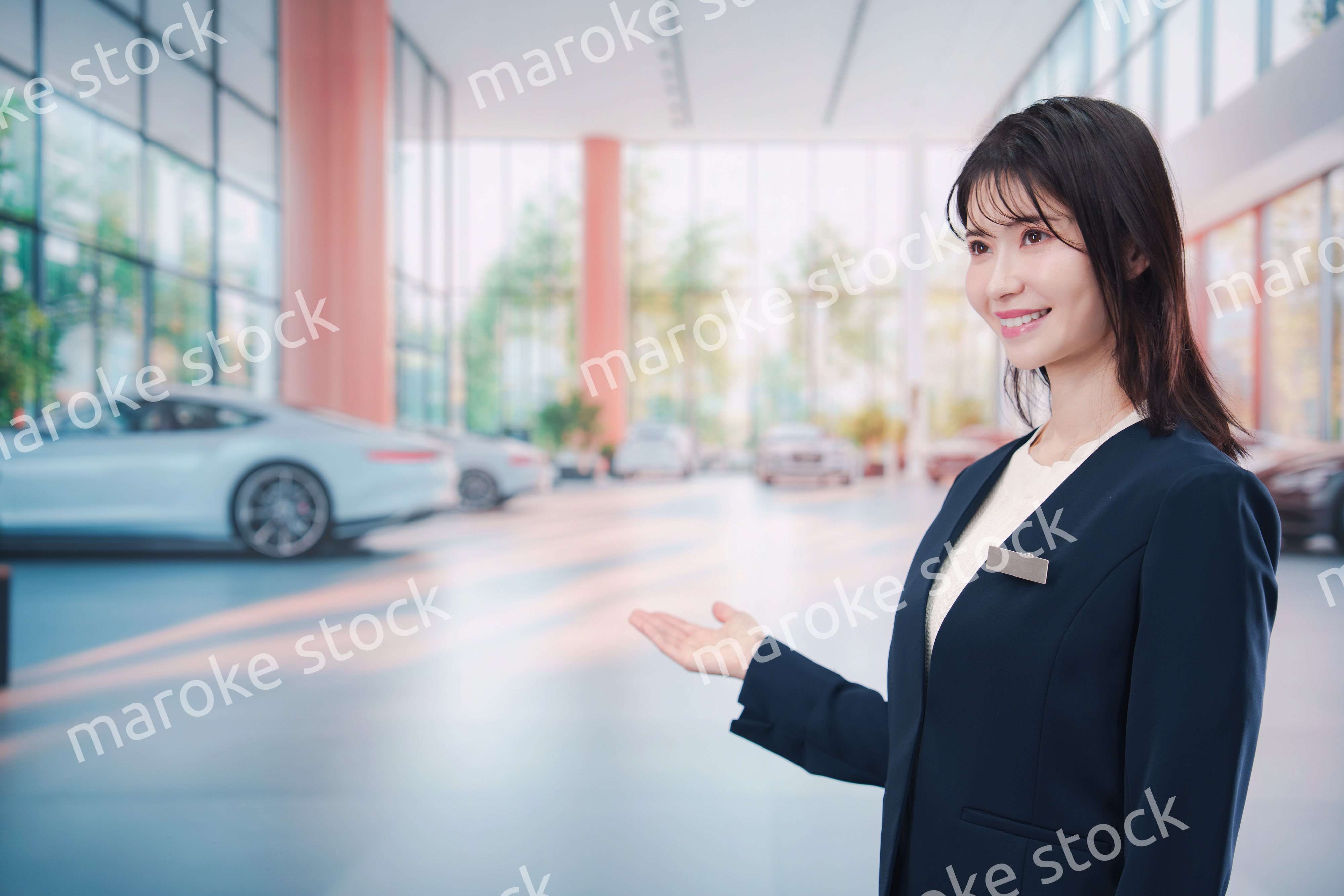 カーディーラーで接客をする若い女性